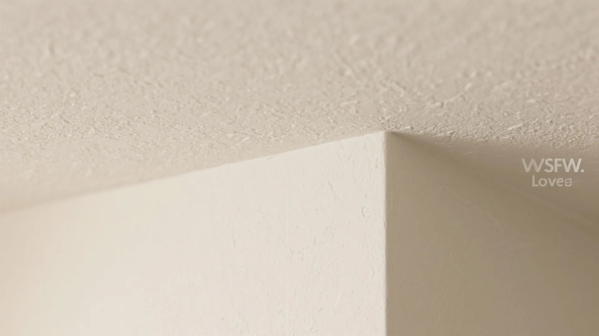 Close up view of white textured wall and ceiling corner showing clean finish and detail