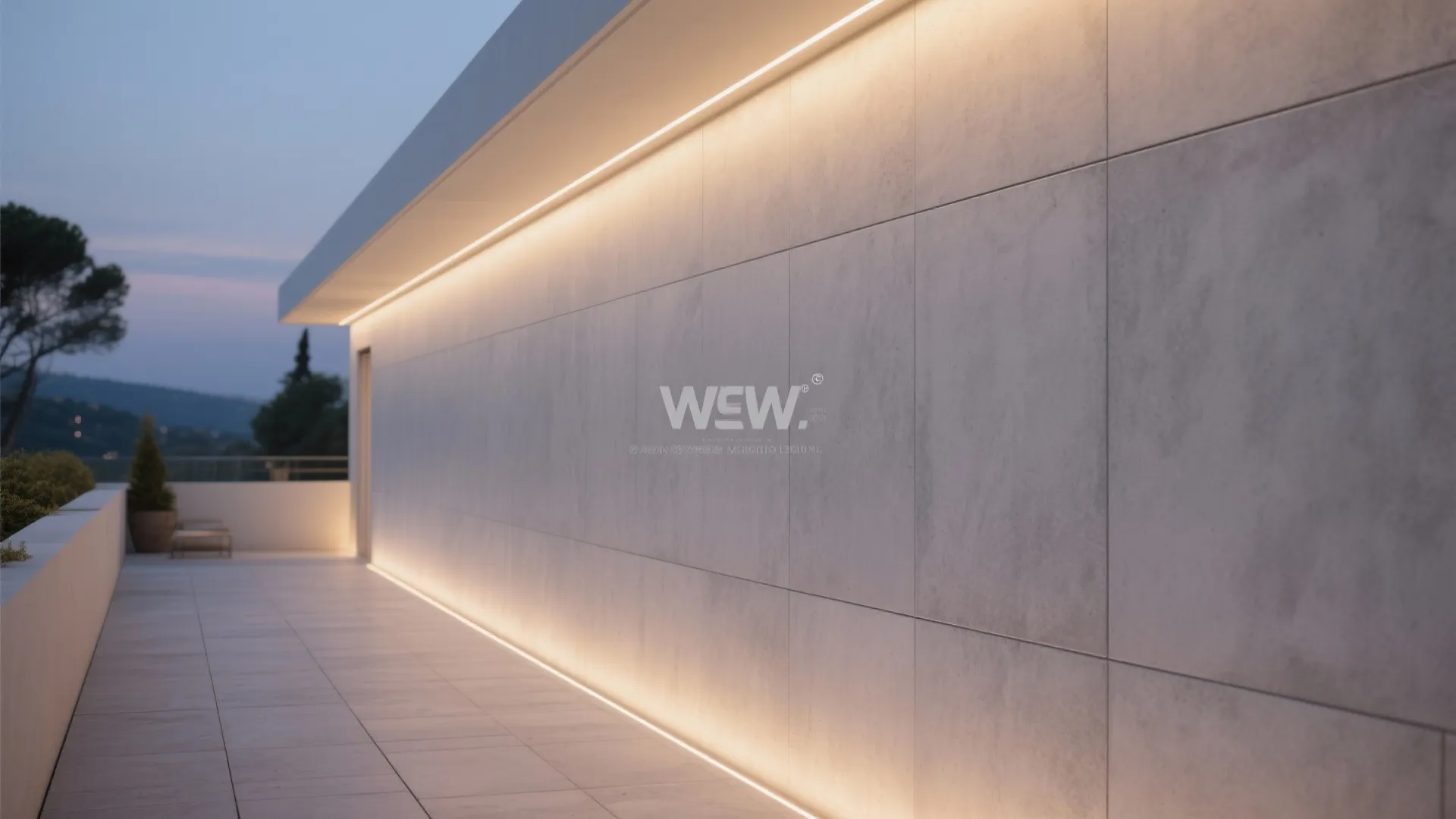 Modern outdoor walkway with large grey wall panels hidden light strips and evening sky background view