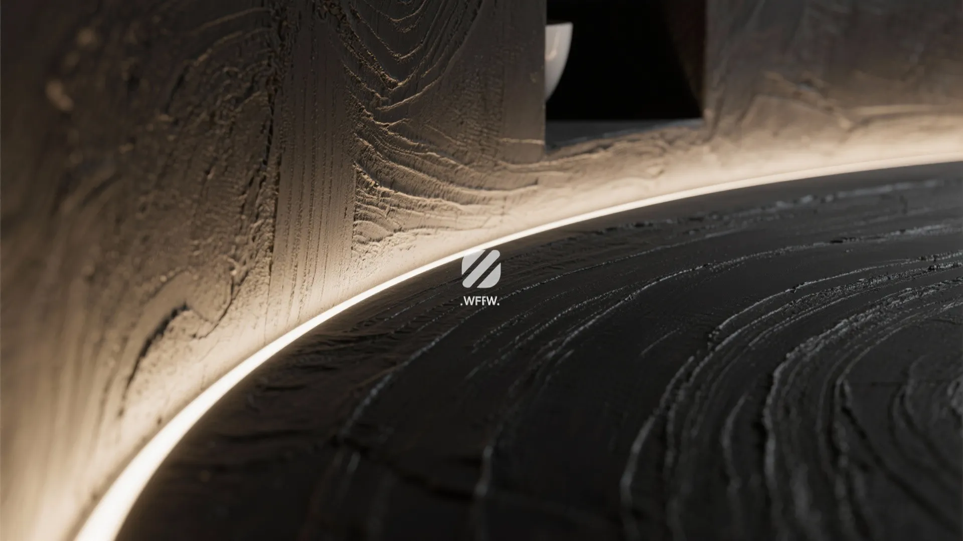 Macro of black microcement curved corner with soft LED glow in a niche.