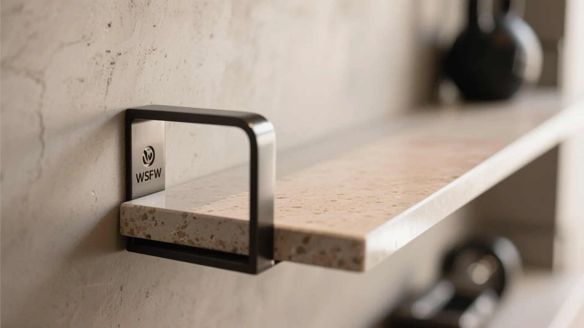 Close up of a stone shelf with a black metal bracket mounted on a textured wall