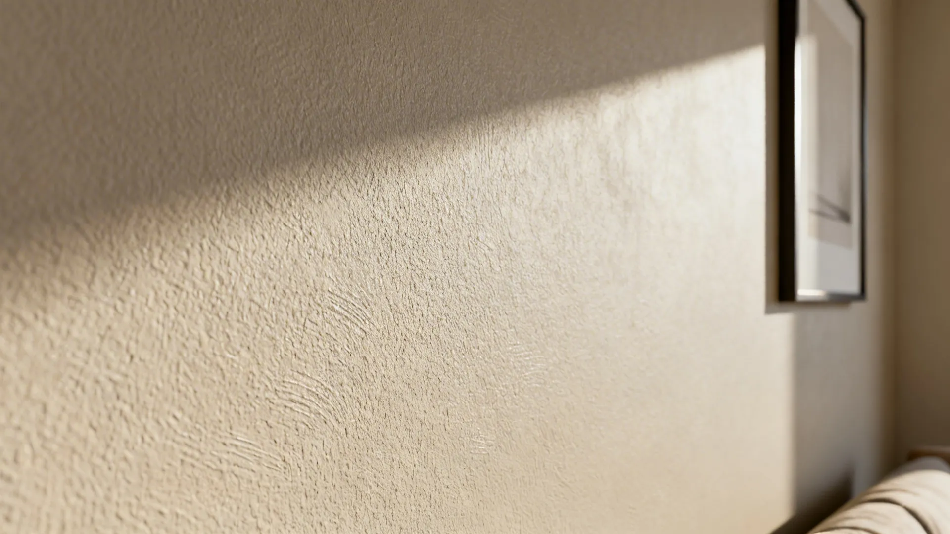 Macro of warm neutral microtextured wall showing fine grain and soft light.