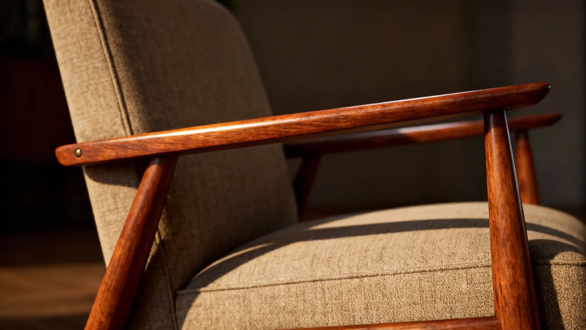 Close-up of a mid-century armchair showing tapered wooden arms and teak grain.