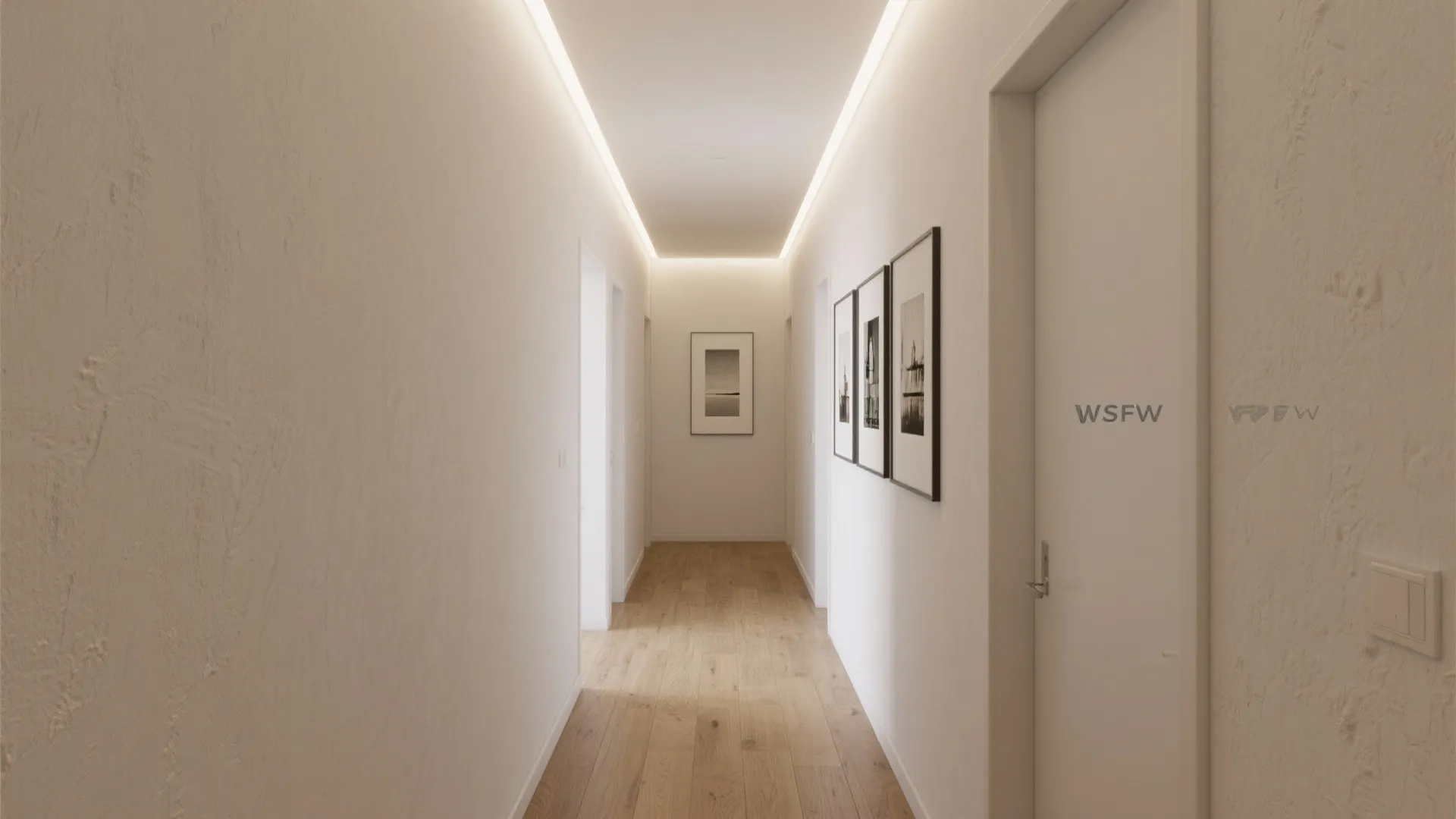 White hallway with wood floor, picture frames on wall, and bright hidden light on ceiling