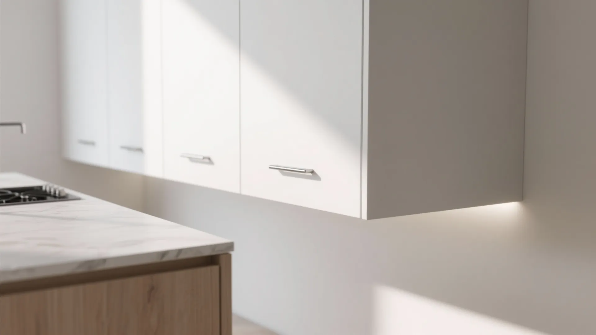 Modern white kitchen cabinet with silver metal handles under bright sunlight and marble stone countertop