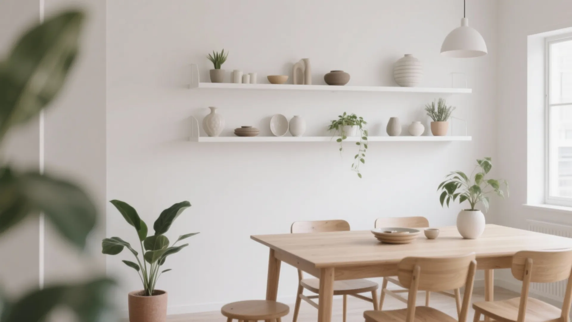 Minimalist white wall with floating shelves above a wooden dining table and chairs with plants