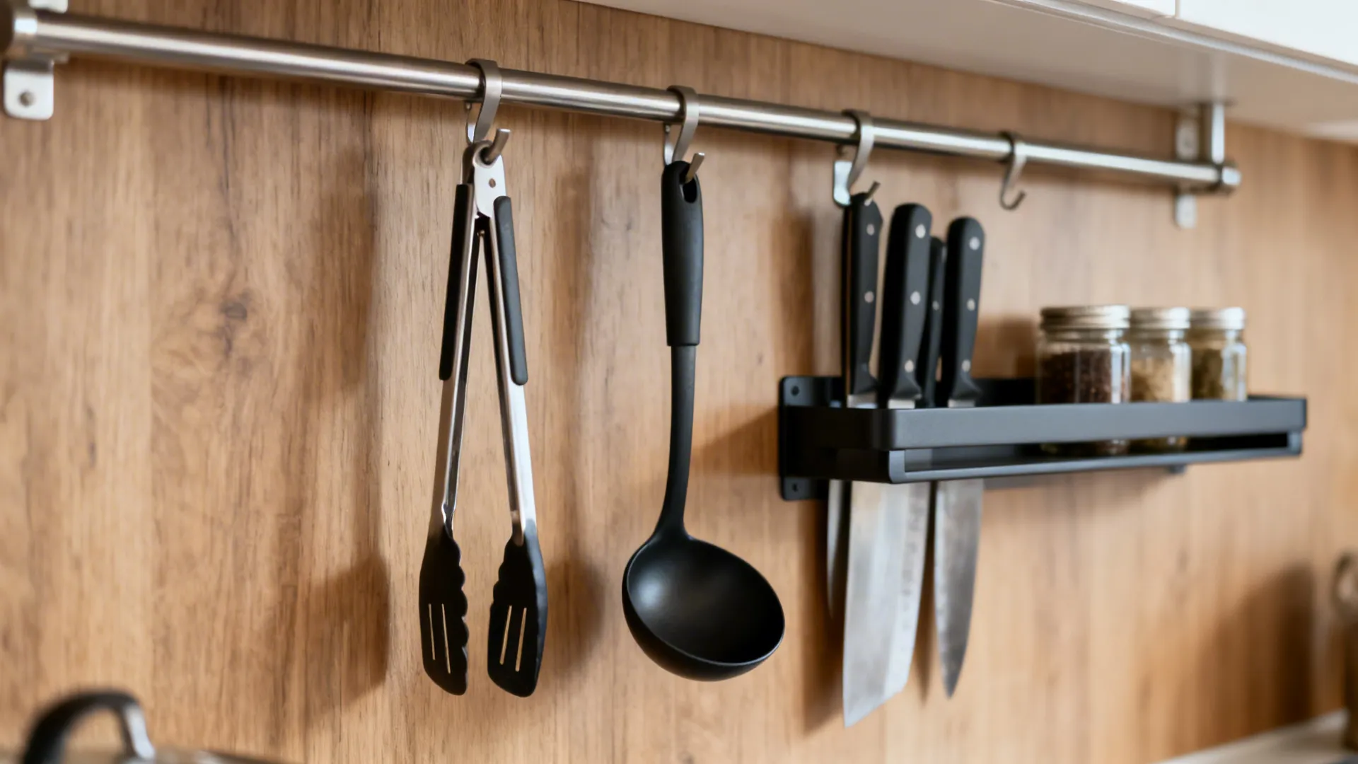 Slim stainless rail and magnetic knife strip near a gas stove with clean, minimalist organization.