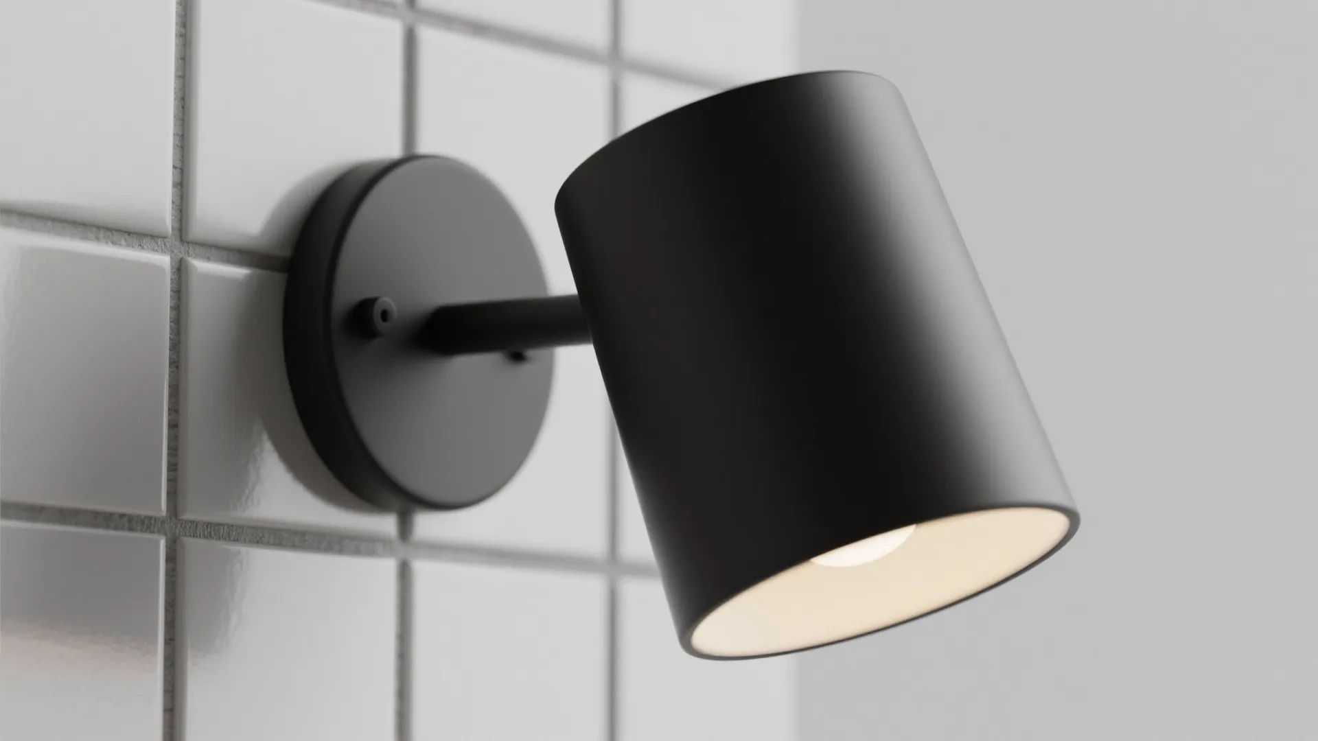 Close up view of a black minimalist wall light fixture installed on a white tiled wall