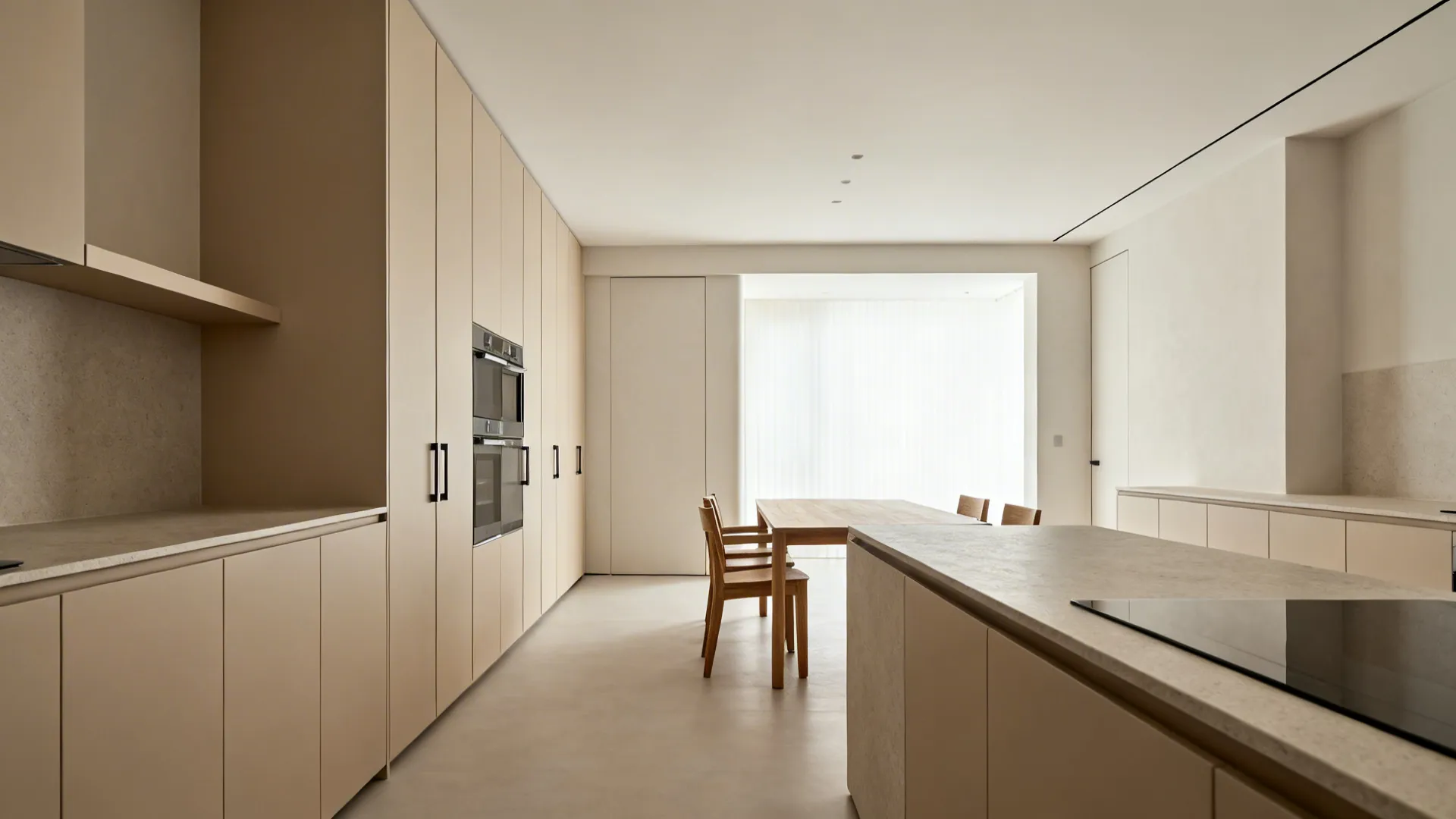 Minimalist kitchen with beige tall cabinets stone island and wooden dining table in bright room