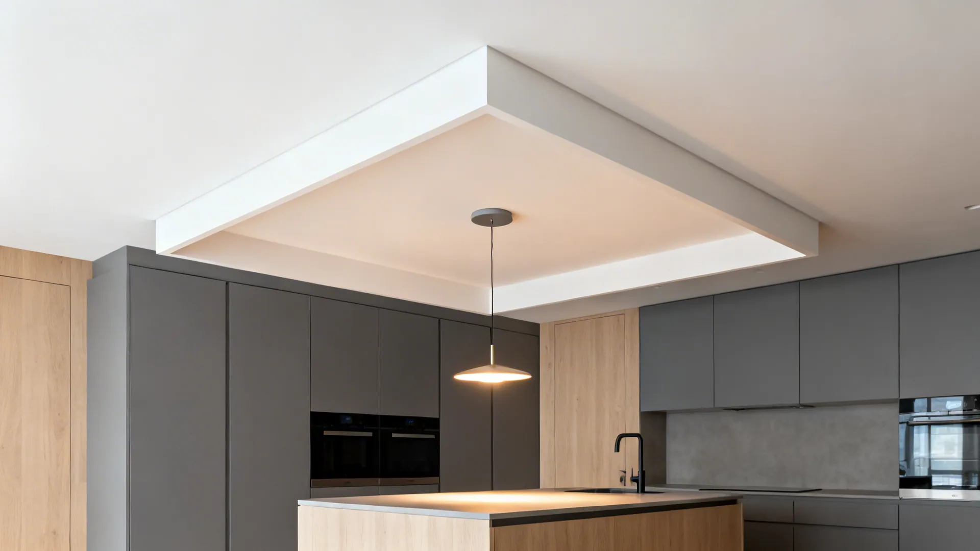 Minimalist kitchen design featuring grey cabinets a wooden island and a simple hanging small ceiling light