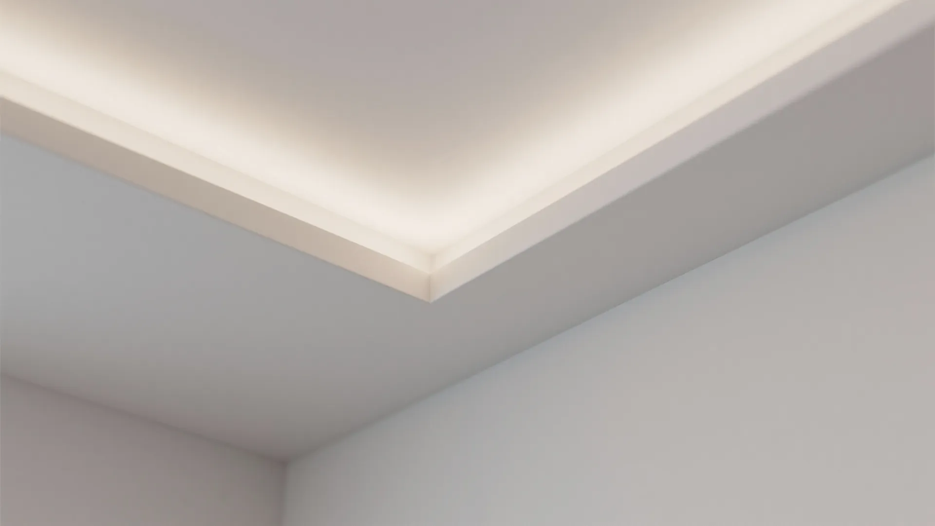 Modern ceiling with hidden light fixture highlighting the corner of a clean white room design