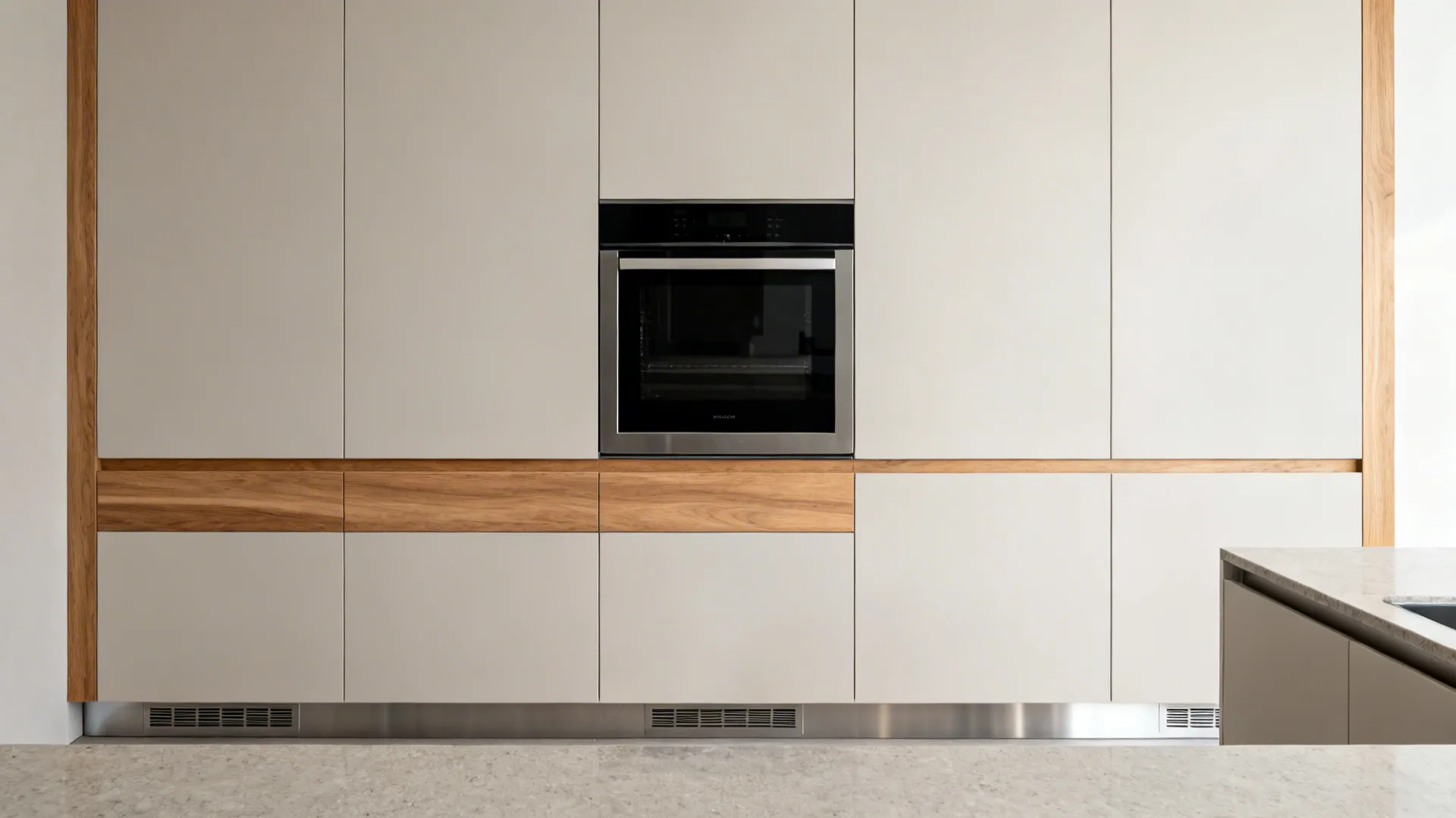 Minimalist kitchen with continuous wood grain, black glass oven, and discreet concealed vent slots.
