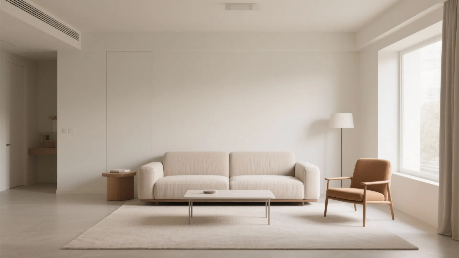 Minimalist living room featuring a cream sofa brown armchair white walls and a large window
