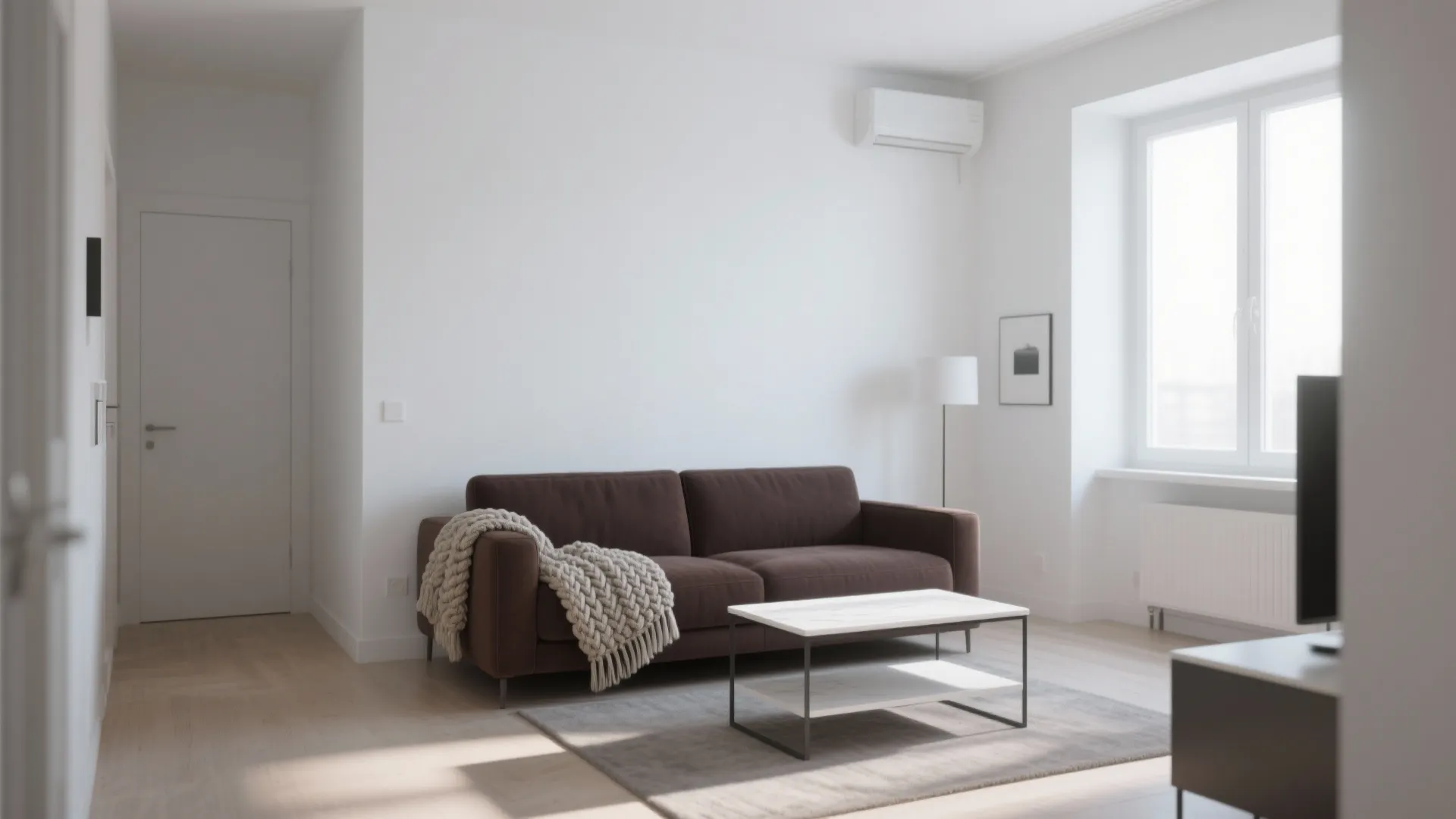 Chocolate brown sofa against bright white walls with a knit throw