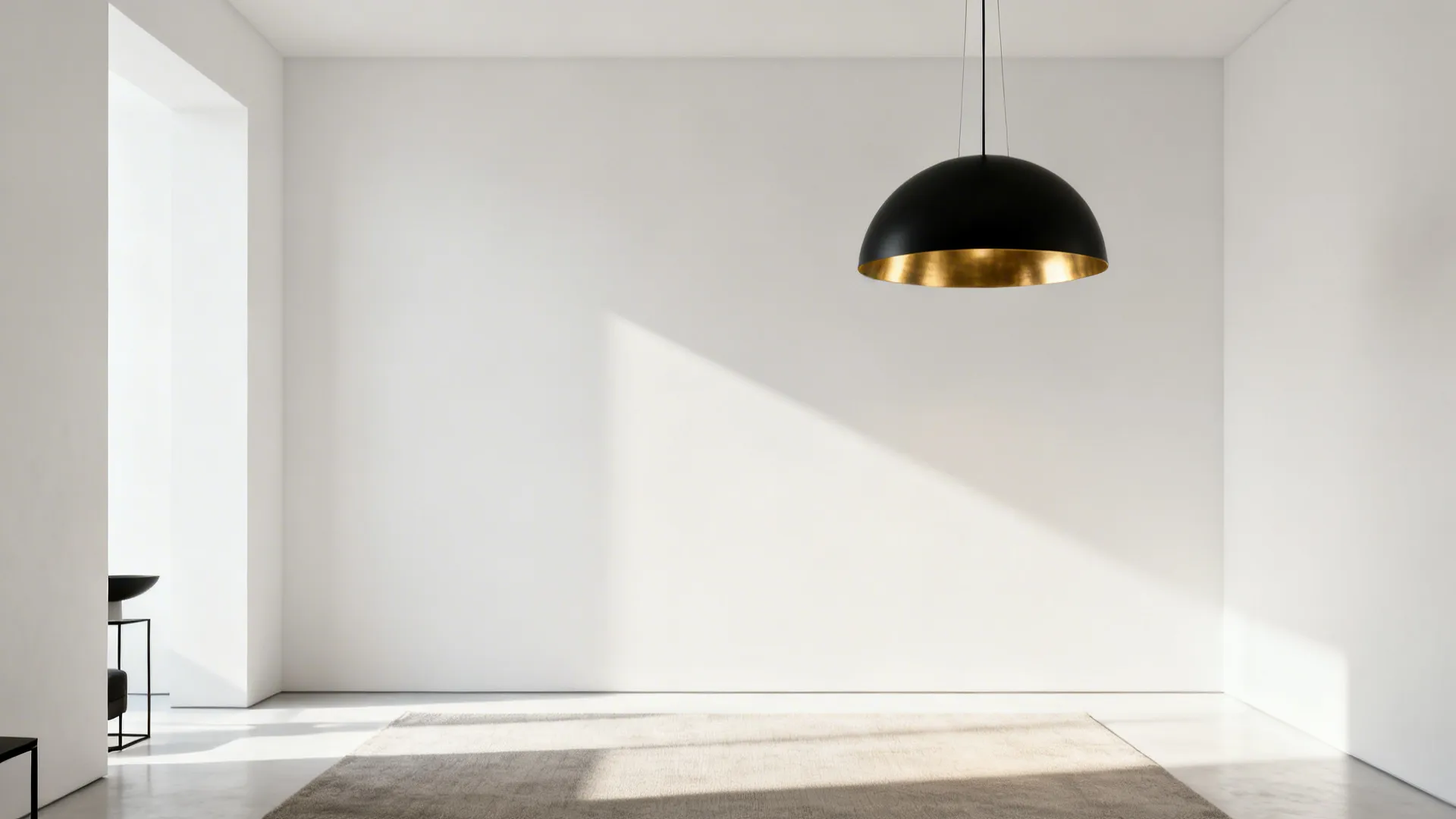 High-contrast minimalist living room with a black chandelier and brushed gold details on a pale backdrop.