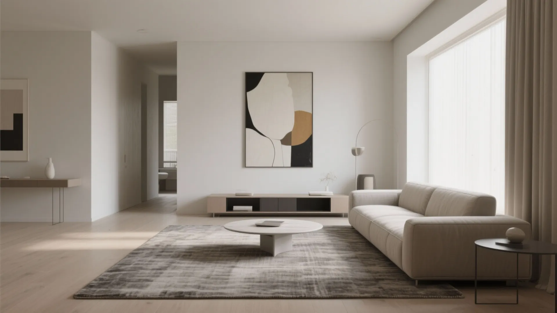 Minimalist living room featuring cream sofa large rug round coffee table and abstract wall art