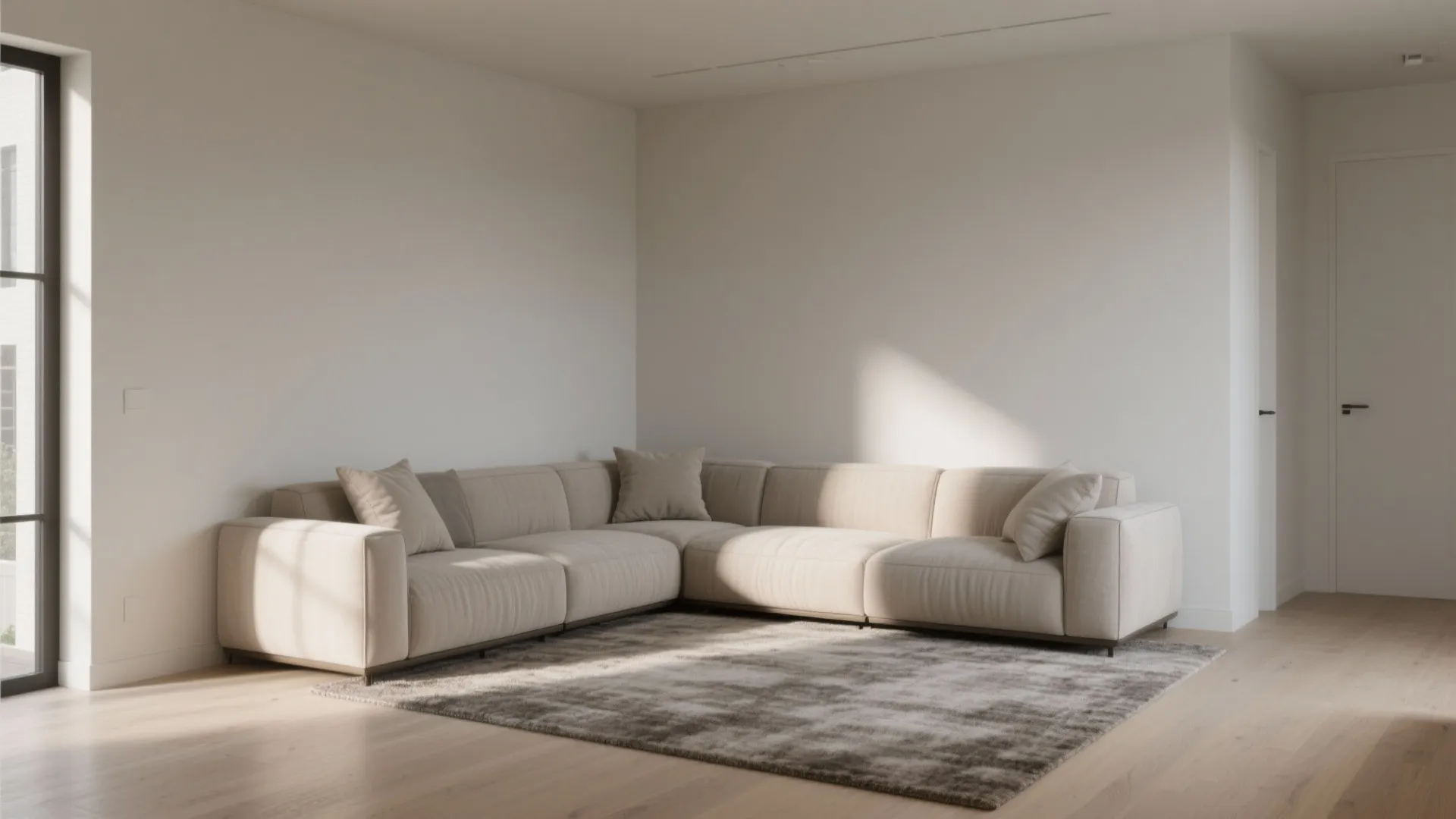 Minimalist room featuring beige sectional sofa in a corner with grey rug and bright walls