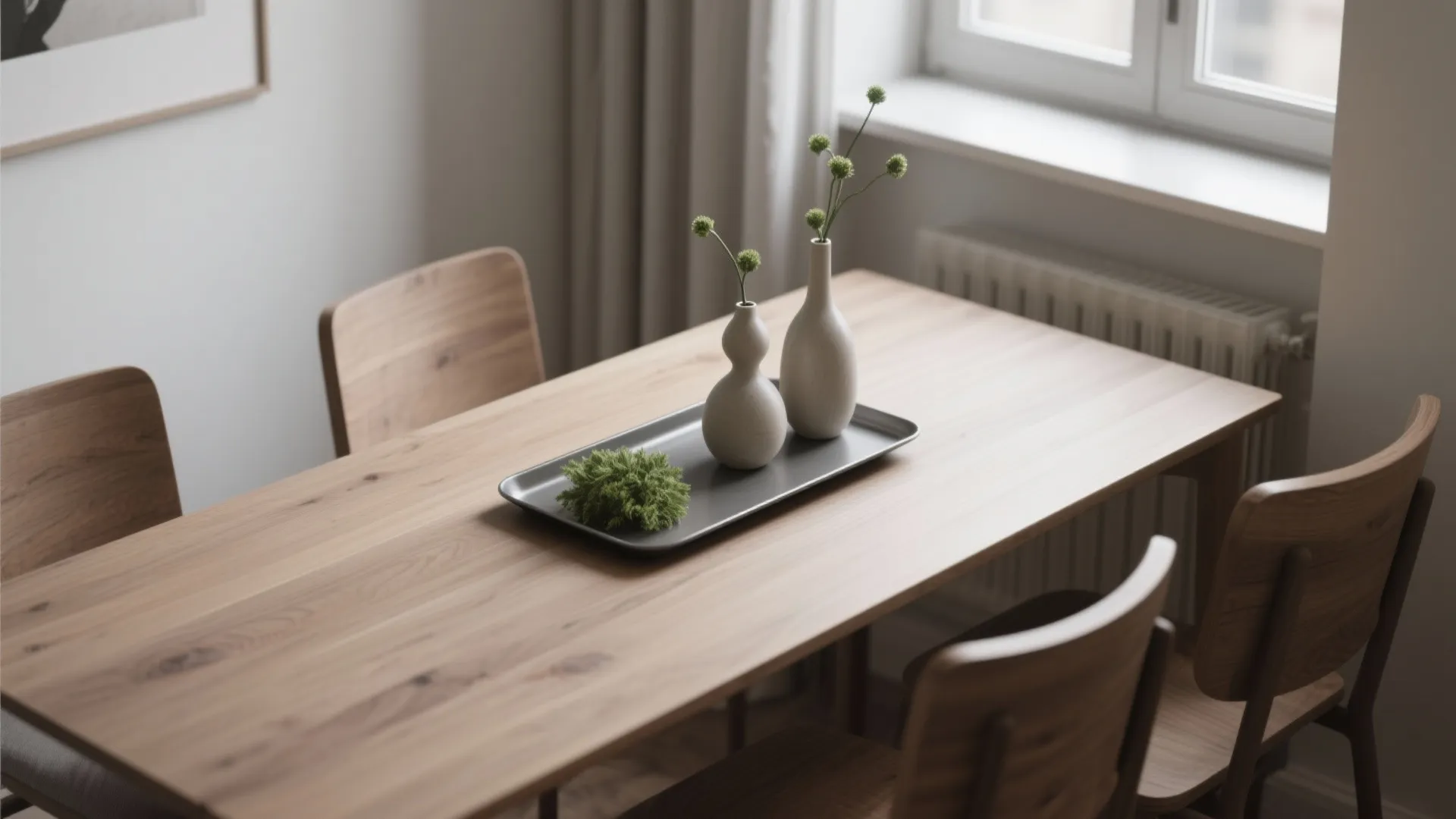 Slim rectangular table with a matte elongated tray holding three bud vases and a low greenery cluster, showing minimalist styling for narrow spaces.