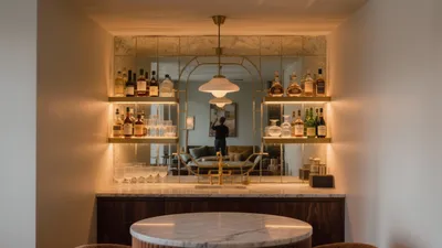Luxury Home Bar with Mirrored Backsplash & Warm Lighting