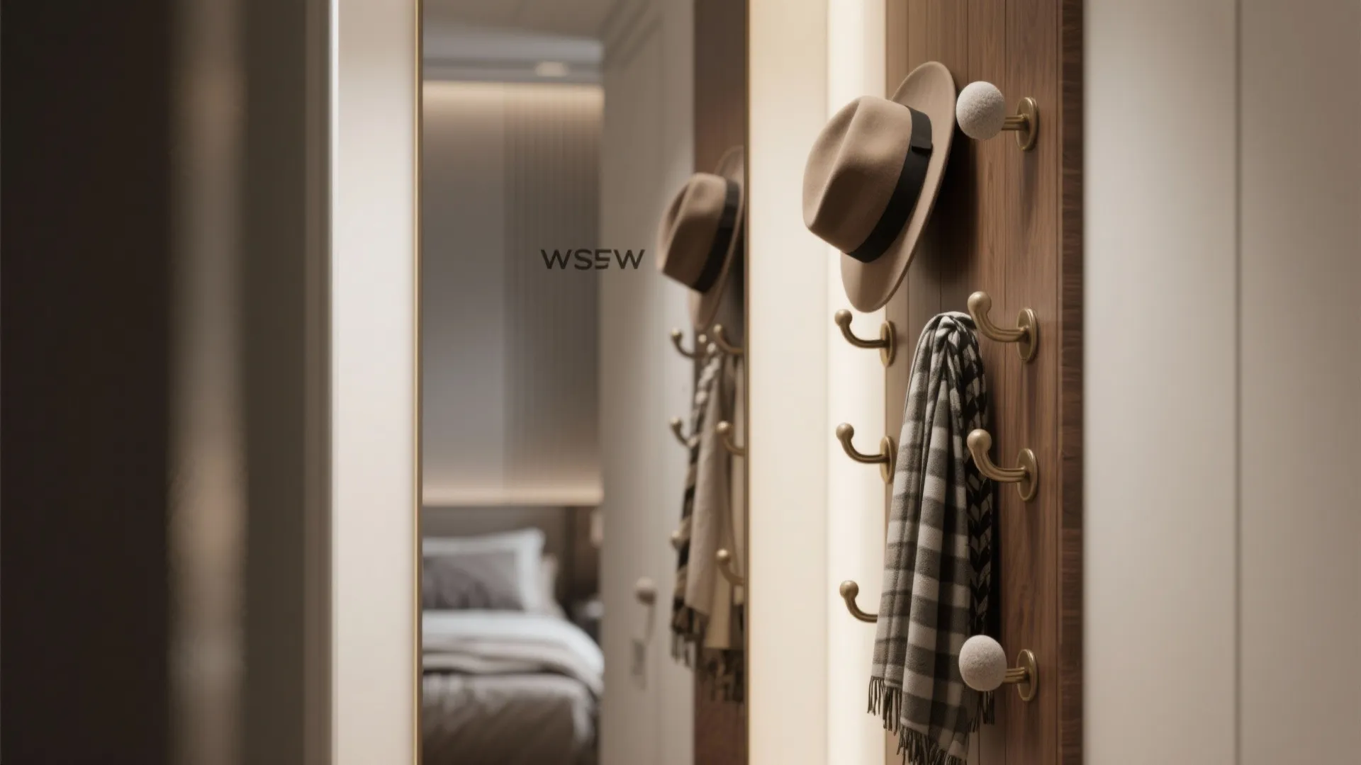 Full-length mirror with a narrow multi-hook strip holding hats, creating a compact dressing area that enlarges the visual space.