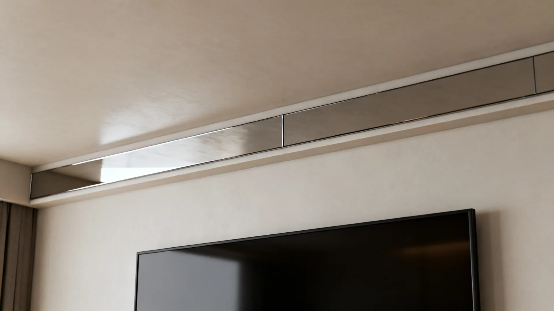Slim mirrored strip above a wall-mounted TV lifting the sightline in a low-ceiling room