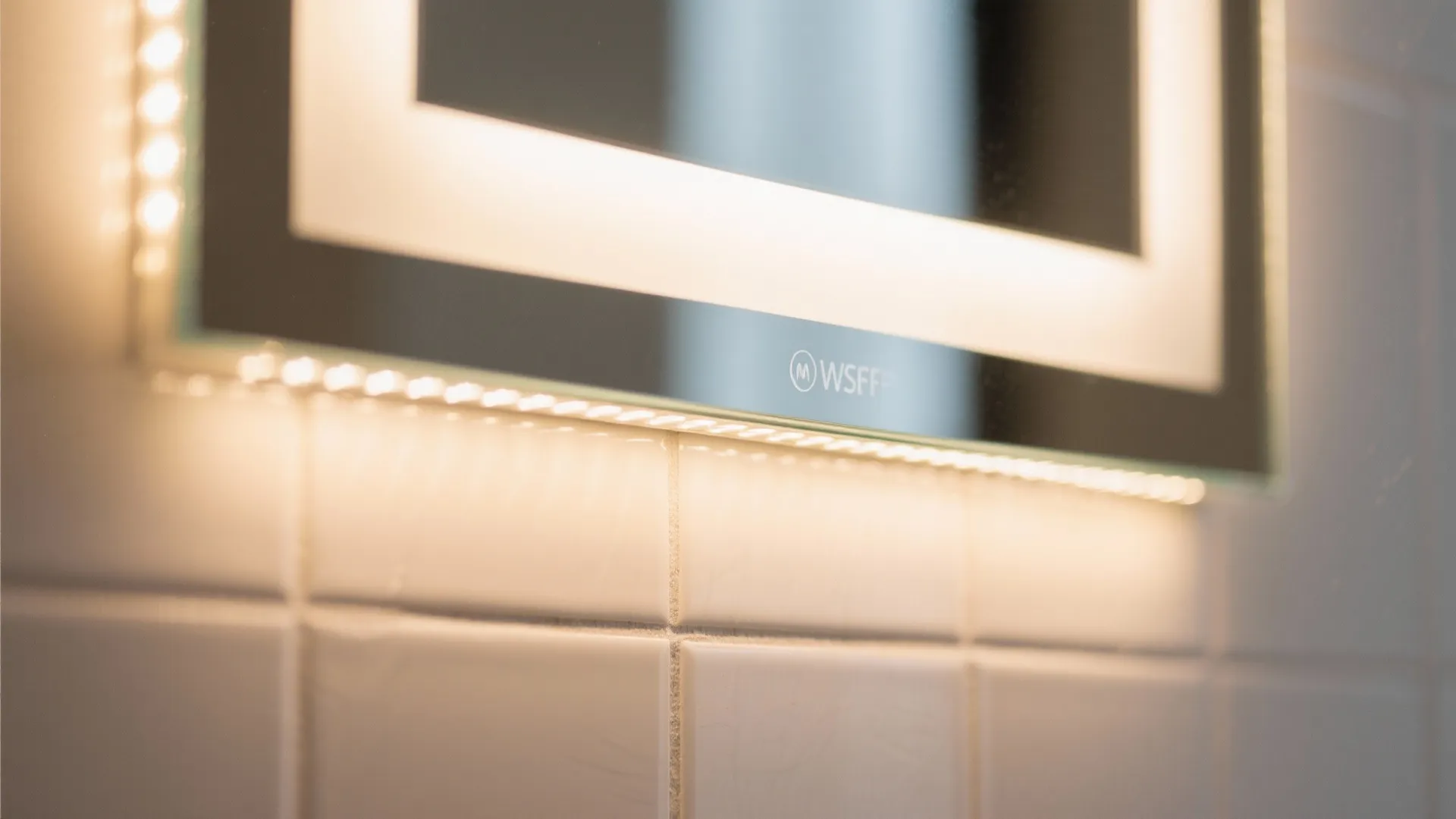 Macro of a mirror with integrated vertical LED strip producing warm, even light.