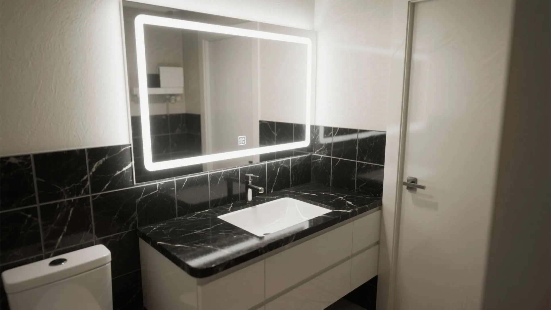 Modern bathroom featuring black marble wall tiles a glowing LED mirror and white cabinet storage