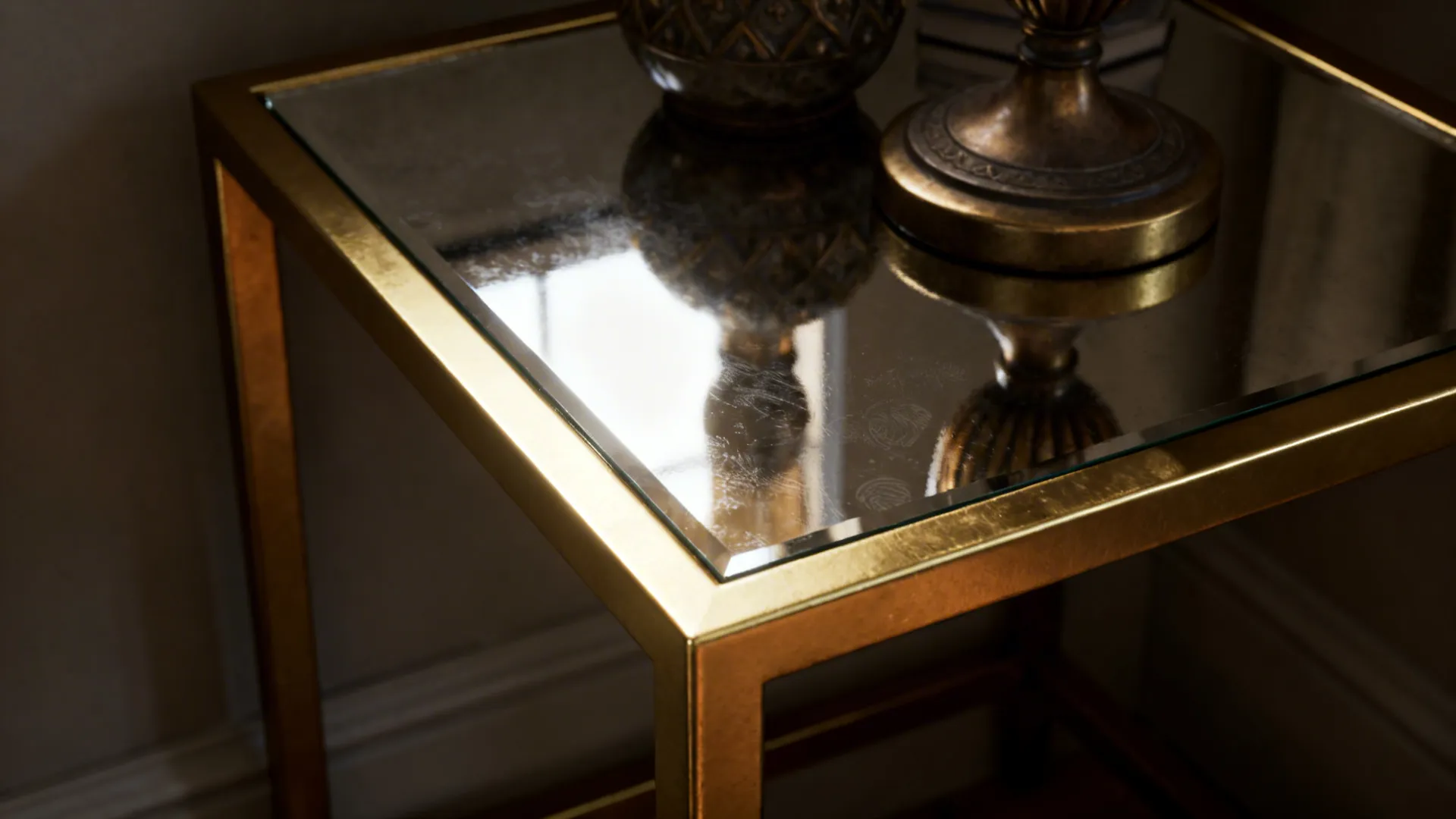 Close-up of a mirrored-top gold end table reflecting light in a small living area.