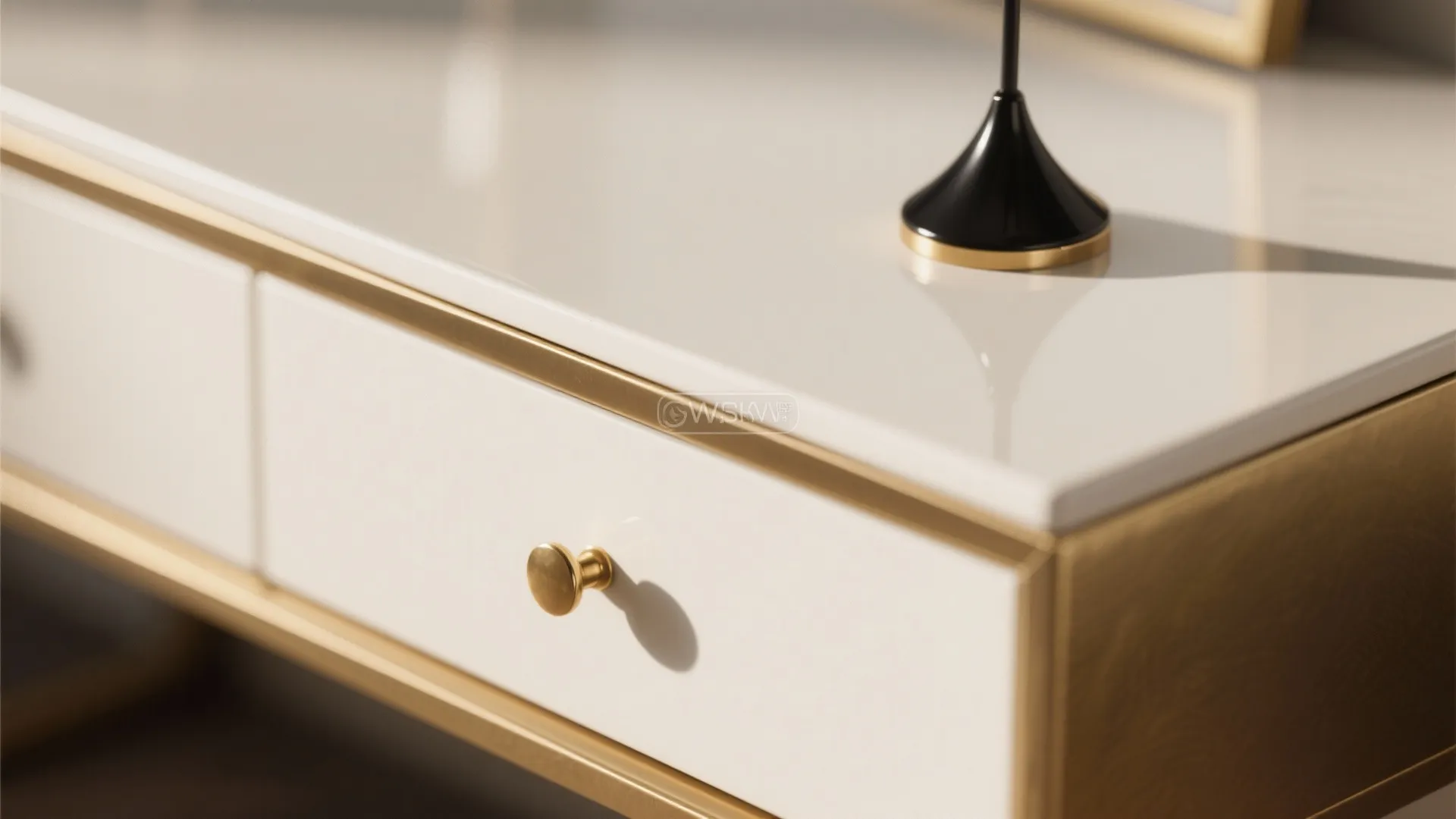 Close up of a white cabinet with gold metal handle and trim showing modern furniture details