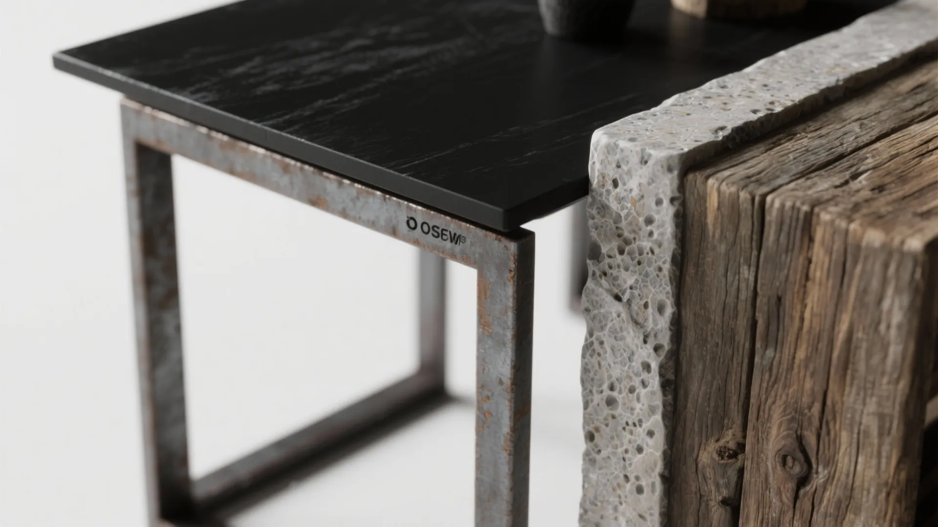 Close-up of a black painted top with raw metal legs and a thin stone inlay next to reclaimed wood grain.