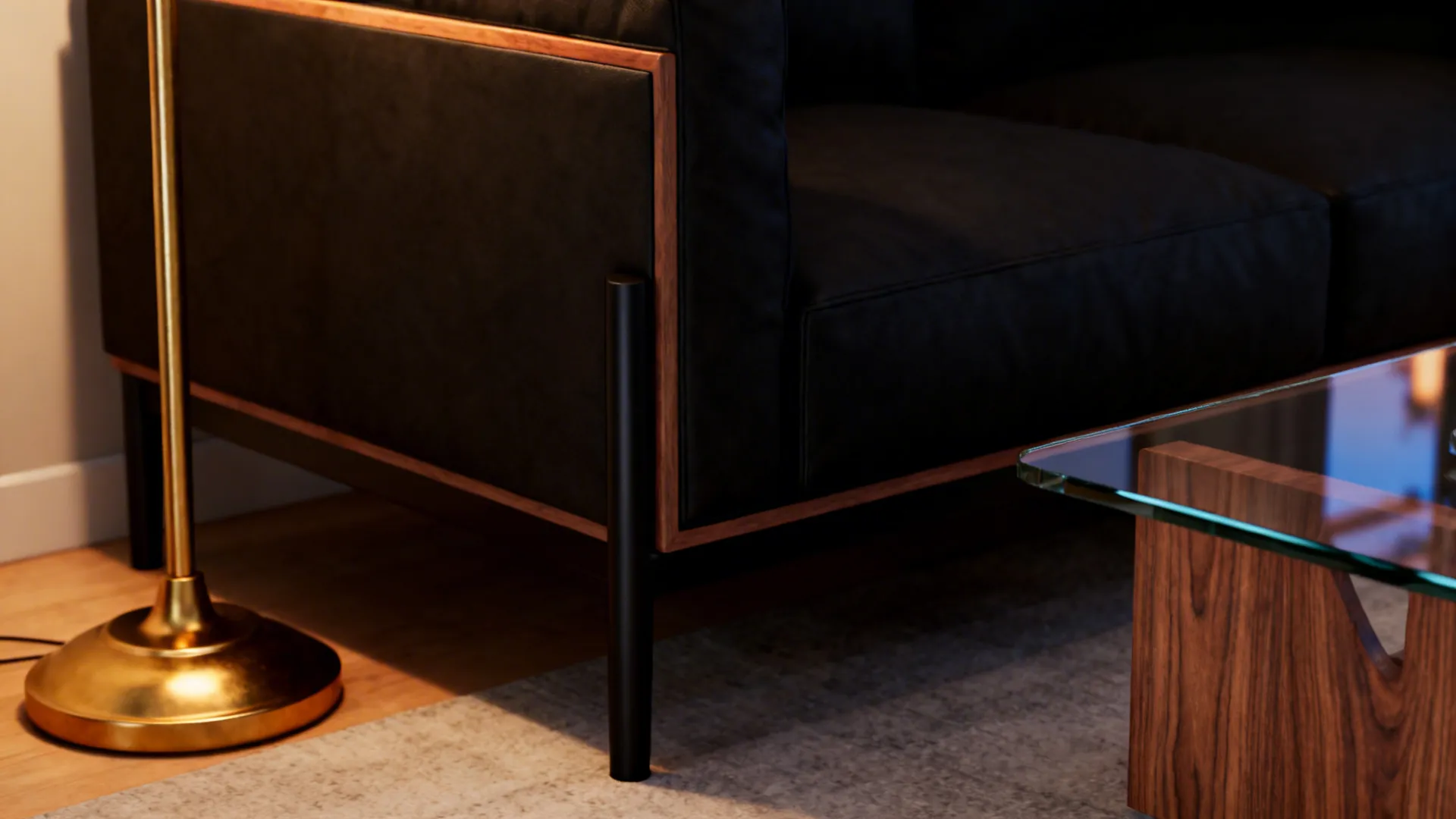 Close view of brass lamp, black sofa leg, glass table and wooden side table showing mixed materials