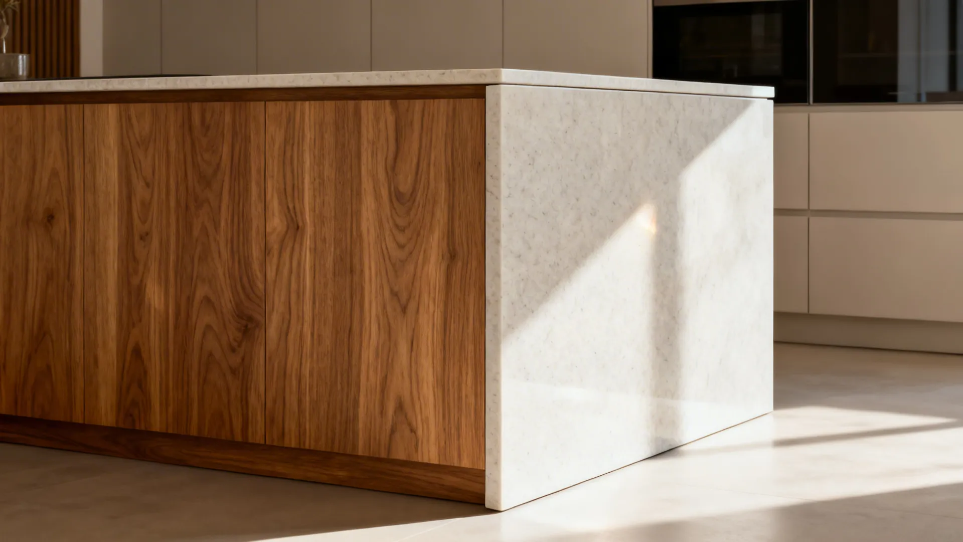 Wood-veneered island back contrasts with a light stone waterfall side in a modern kitchen.