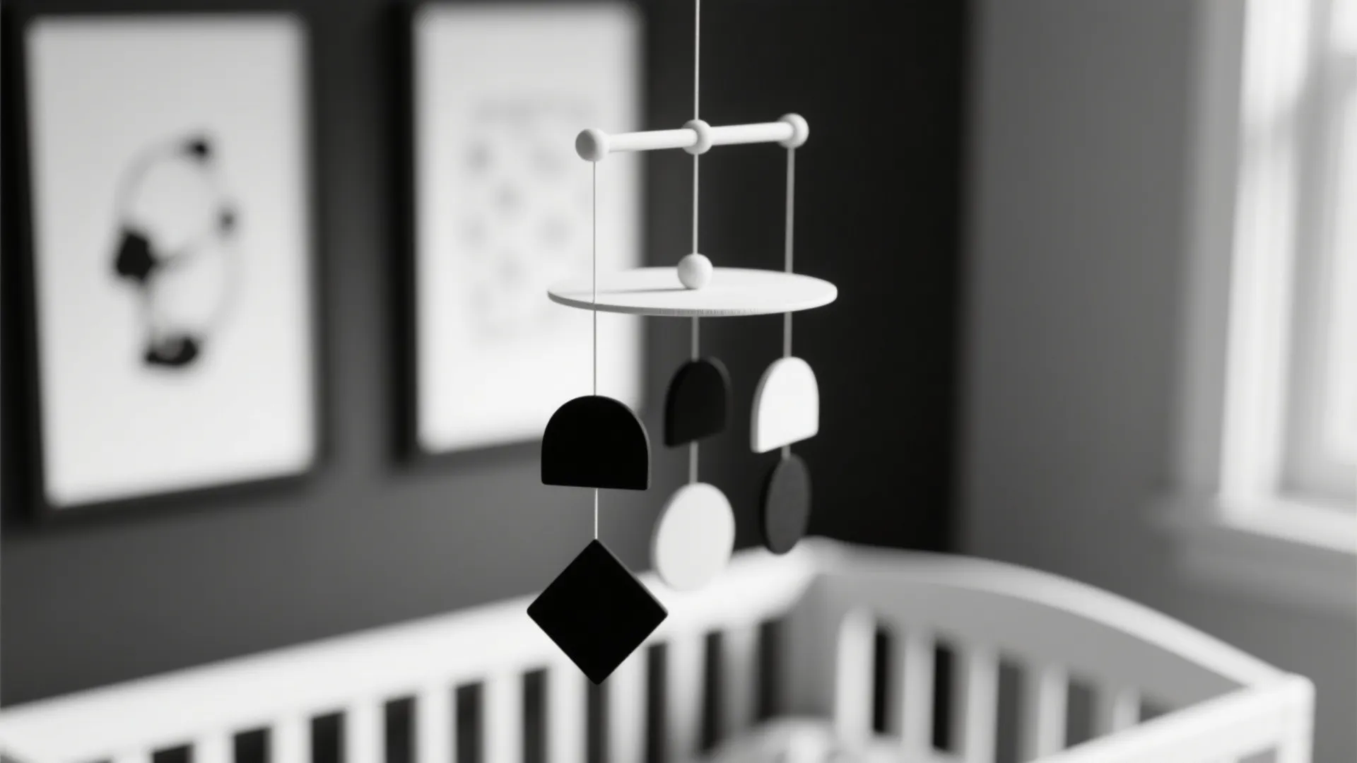 Black and white hanging baby toy above a crib in a modern style nursery room