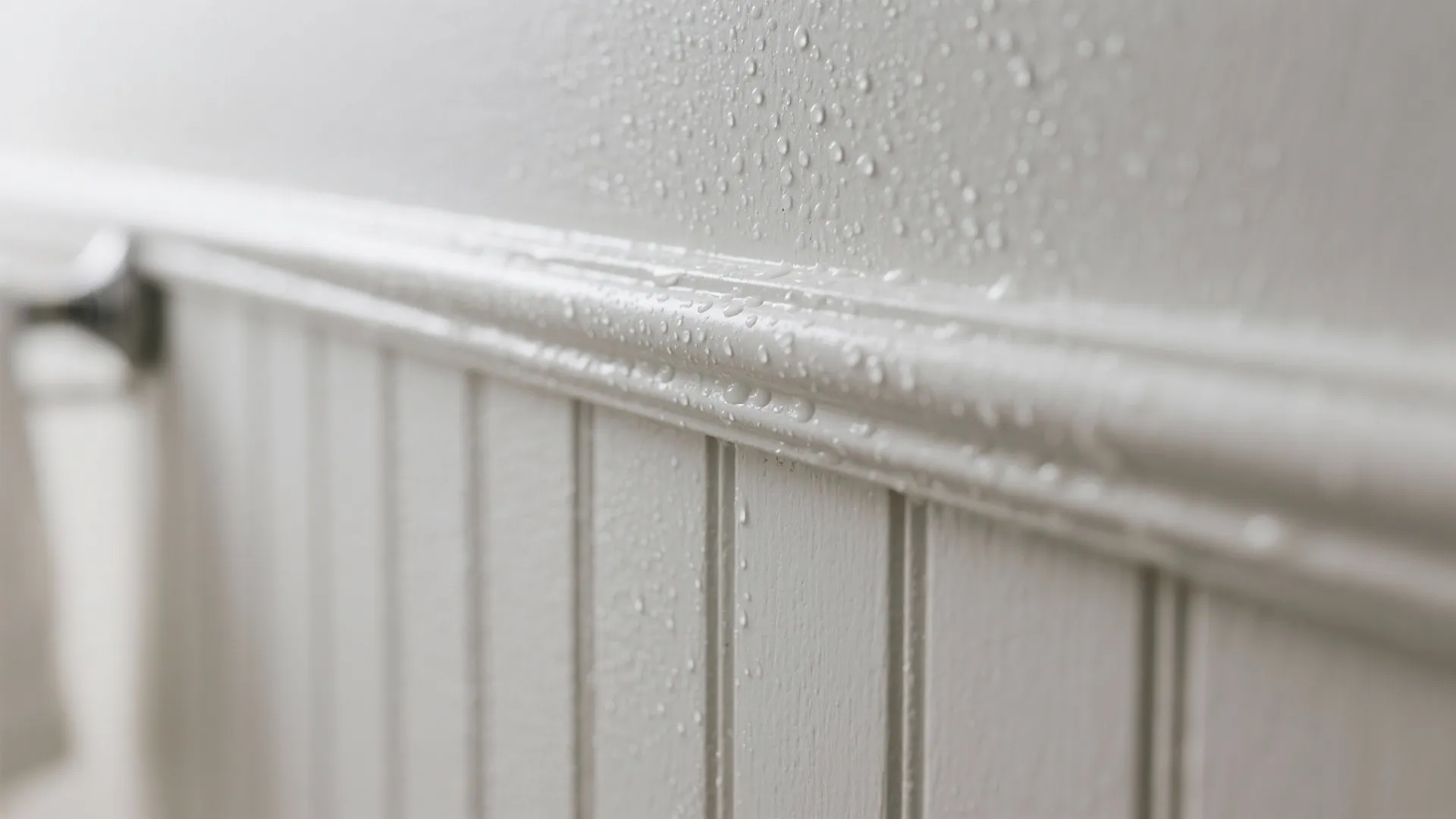 Close up of water drops on white moisture resistant wall panel in a humid bathroom