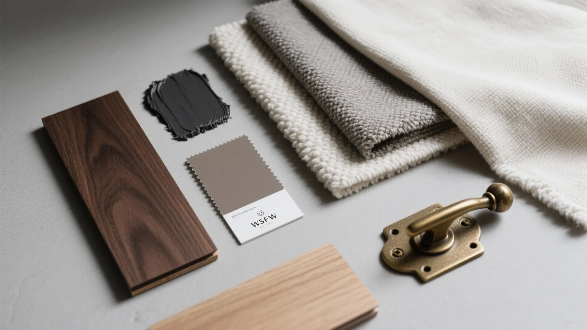 Interior design material board with wood samples fabric swatches paint colors and brass door handle