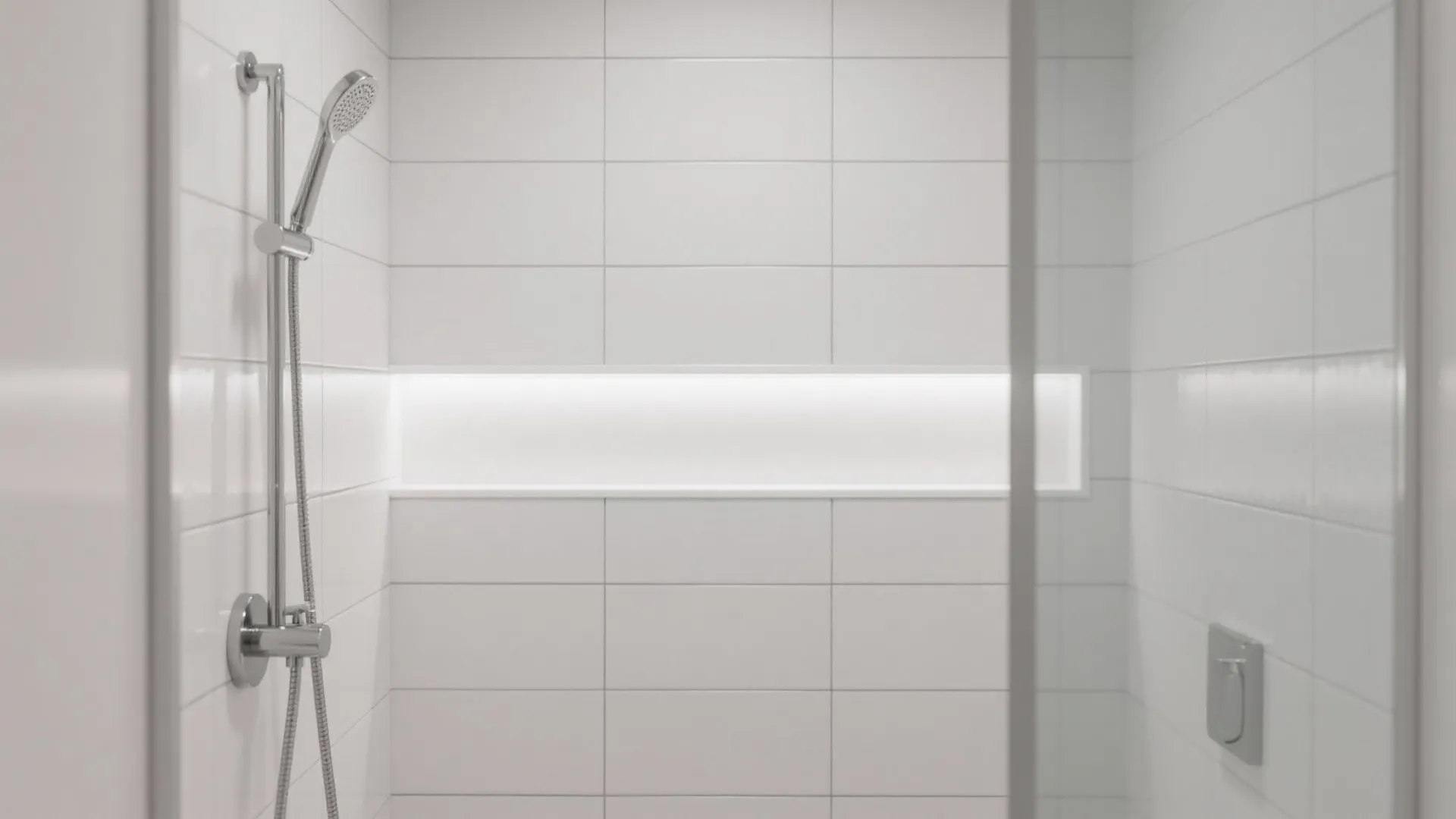 Clean white tiled shower area with a silver shower head and a bright lighted niche