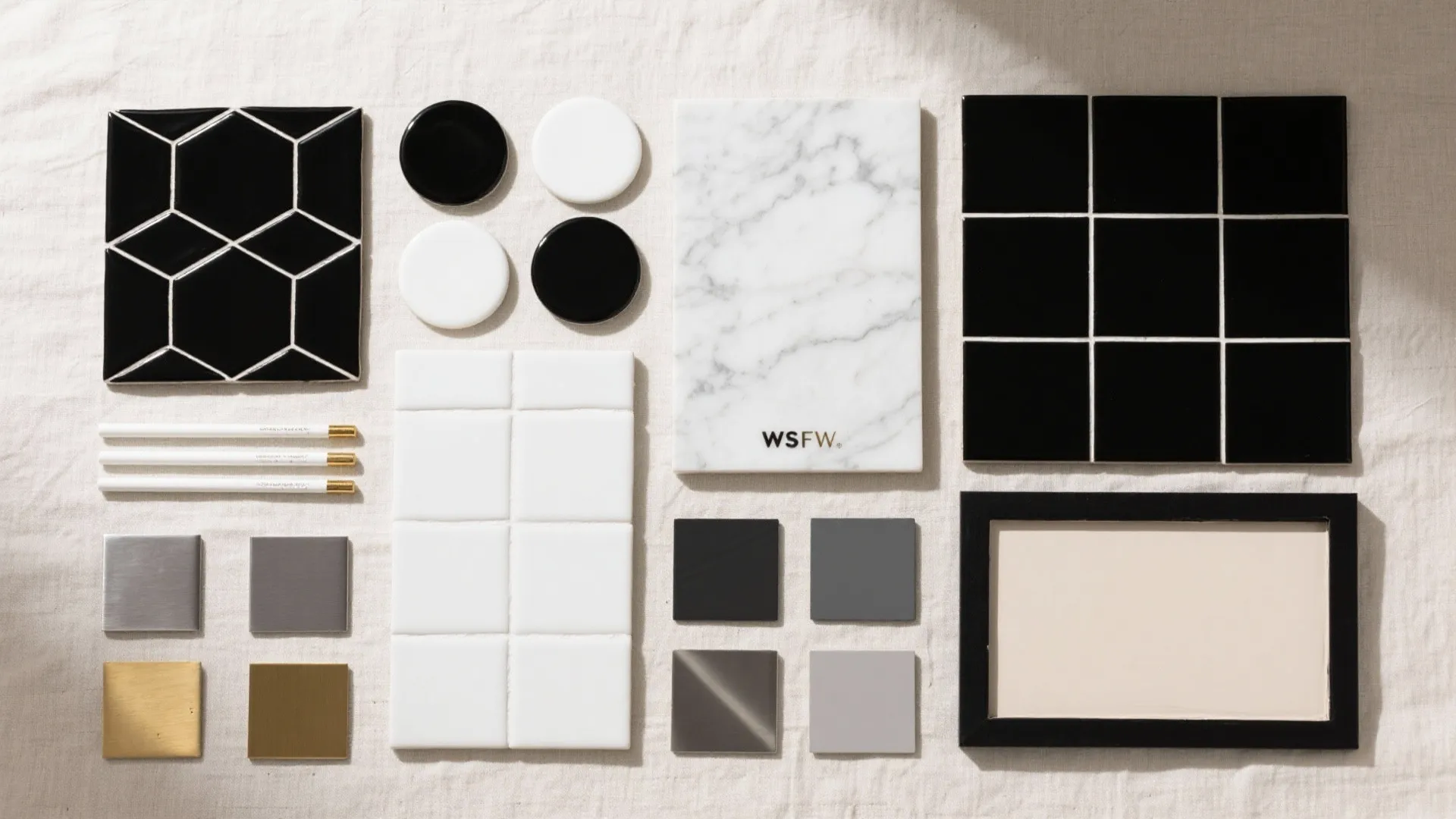 Selection of interior design materials including black and white tiles marble slab and metal samples