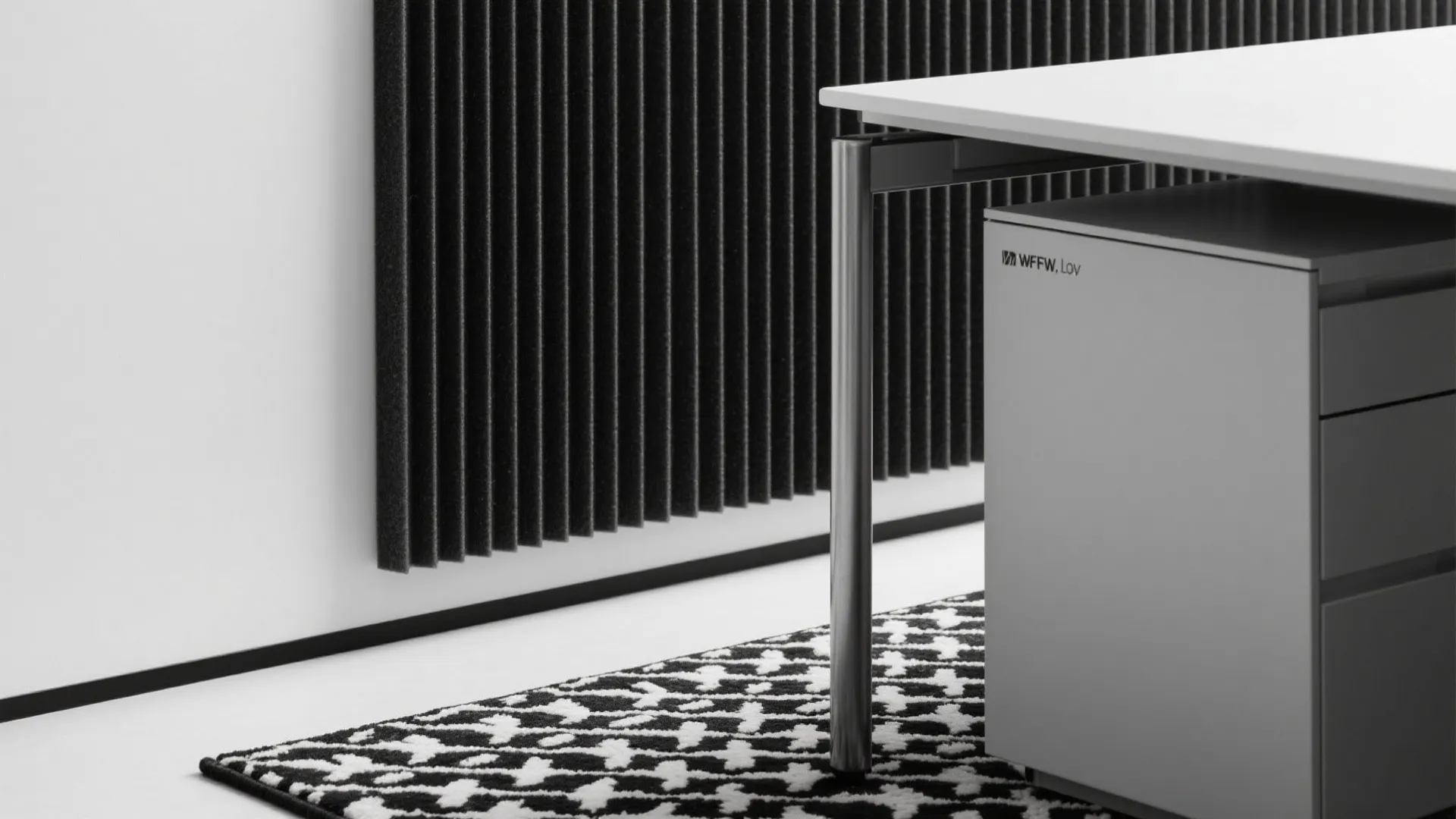 White office desk with grey cabinet a patterned rug and black textured vertical wall panel