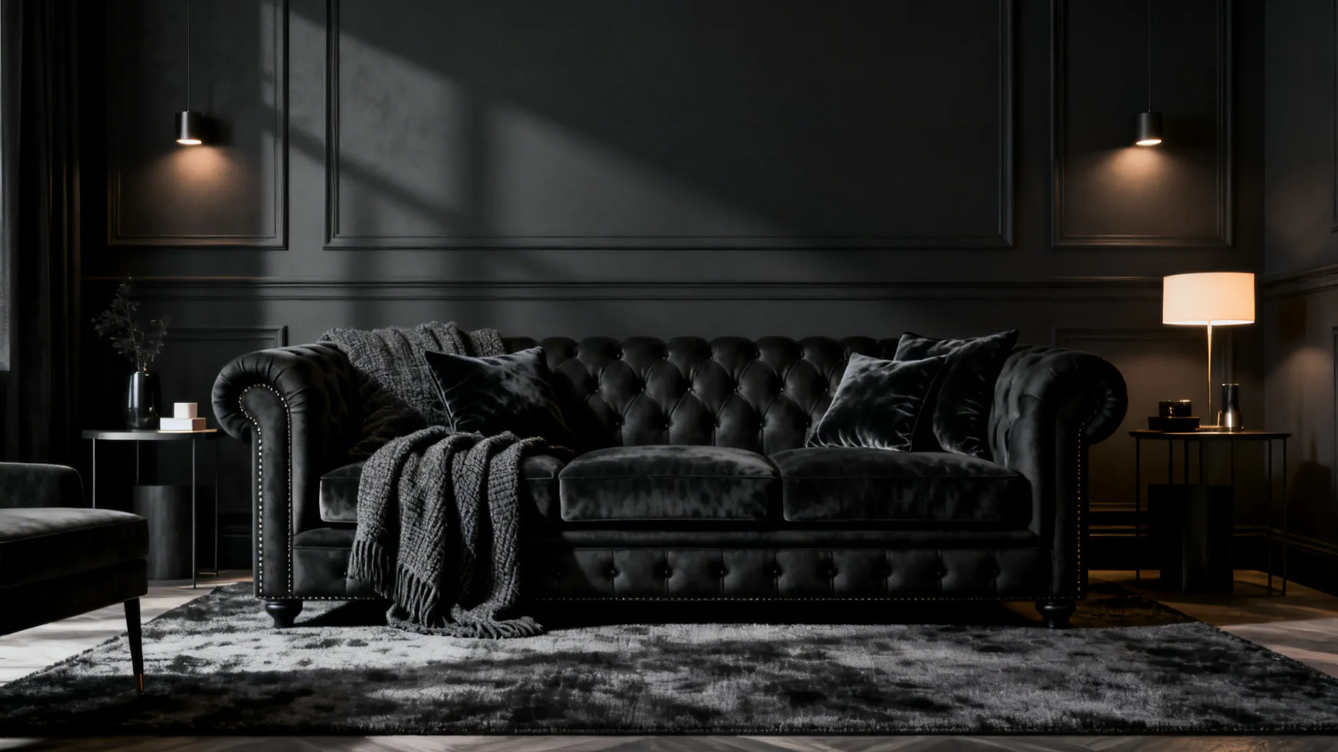 Monochrome living room with a black Chesterfield sofa against deep charcoal walls.