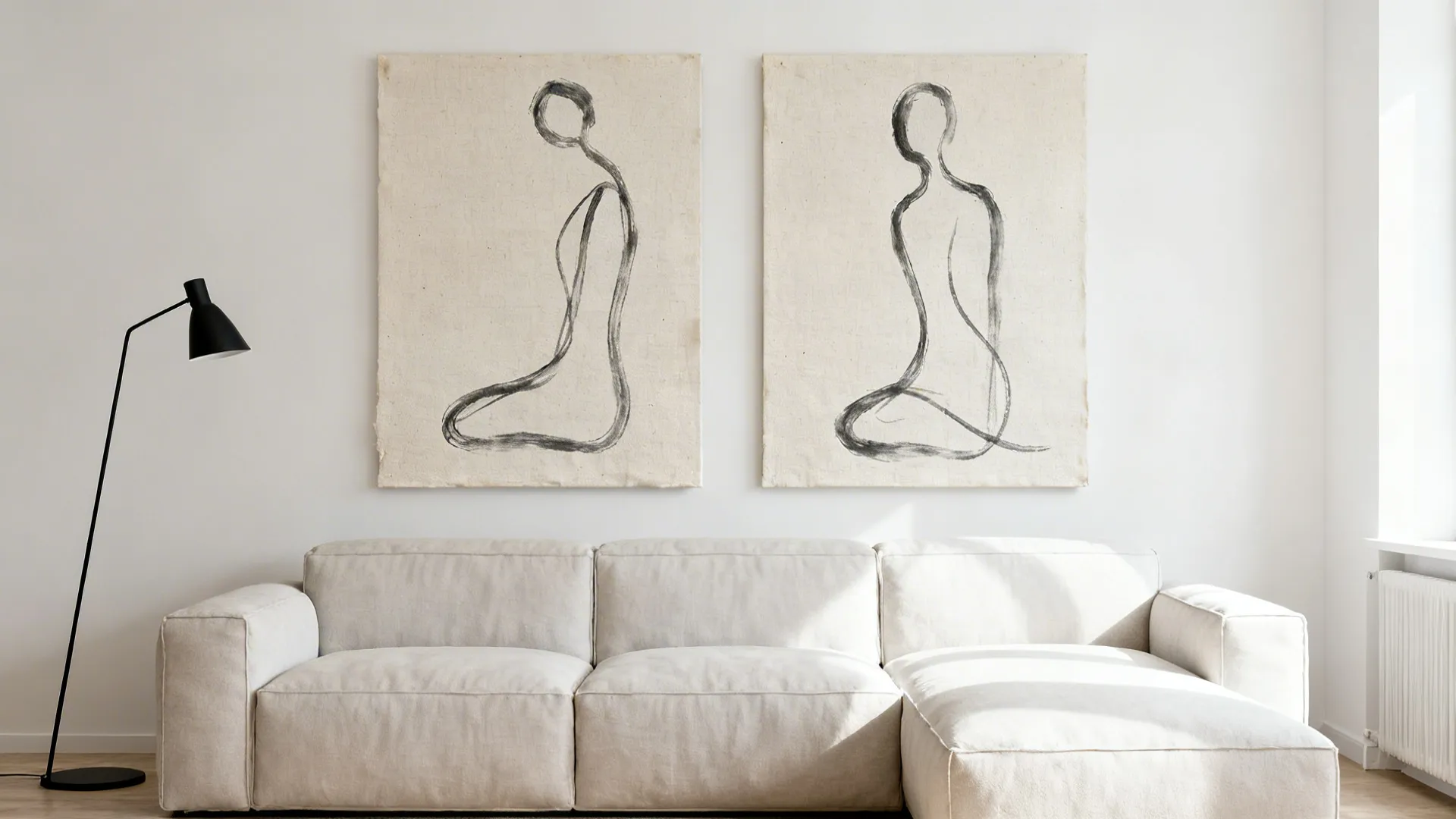 Two canvases with a continuous charcoal line forming abstract shapes above a pale sofa.