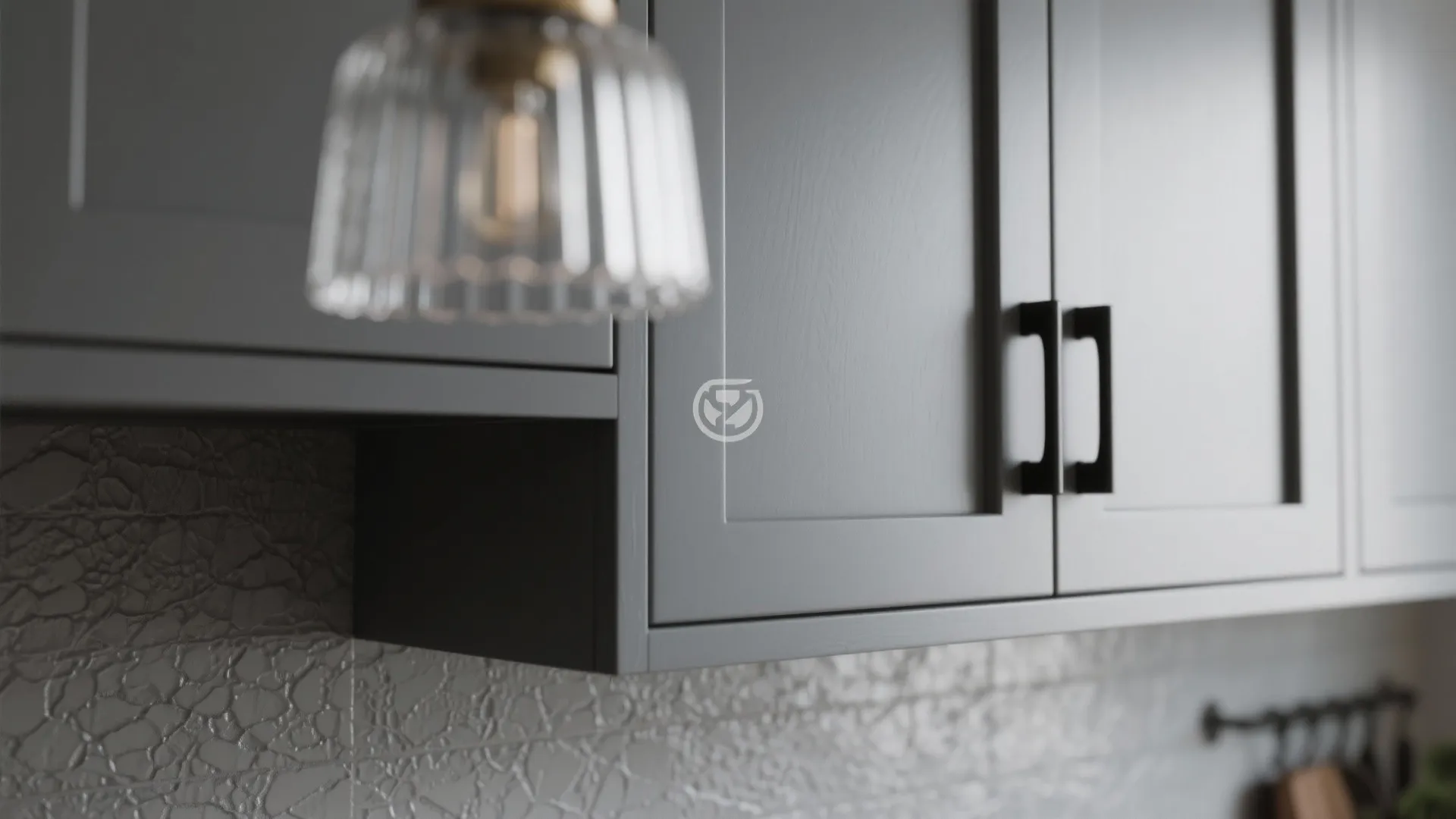 Close-up of grey shaker cabinet with matte black hardware and textured backsplash