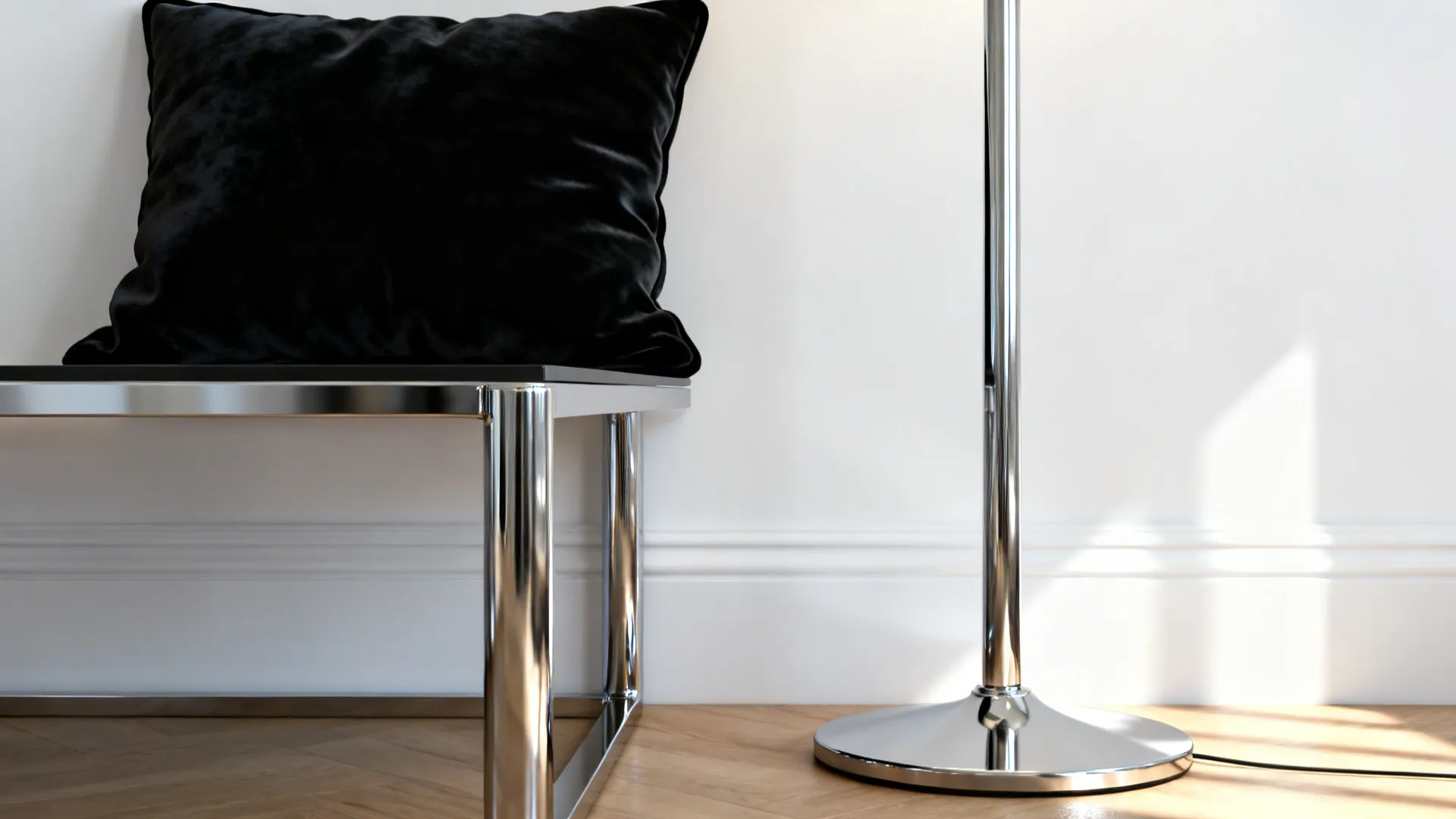 Black velvet pillow on chrome bench next to silver metal floor lamp and white wall