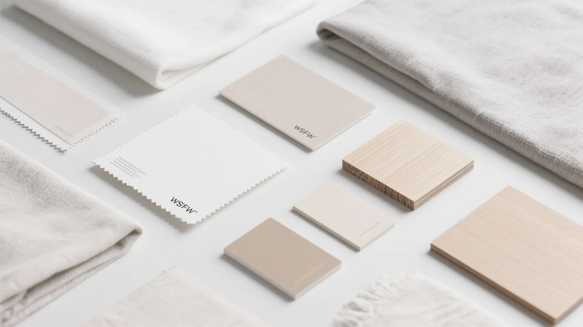 Minimalist collection of beige fabric samples and light wood panels for professional interior design projects