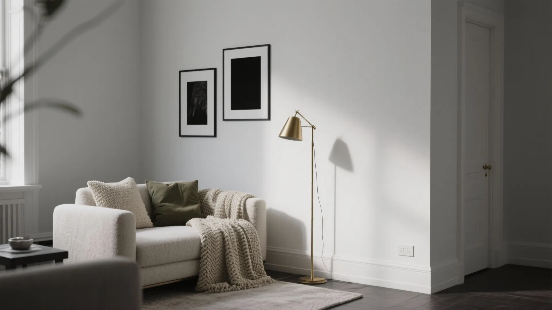 Minimalist living room corner with small sofa gold floor light framed wall art and blanket