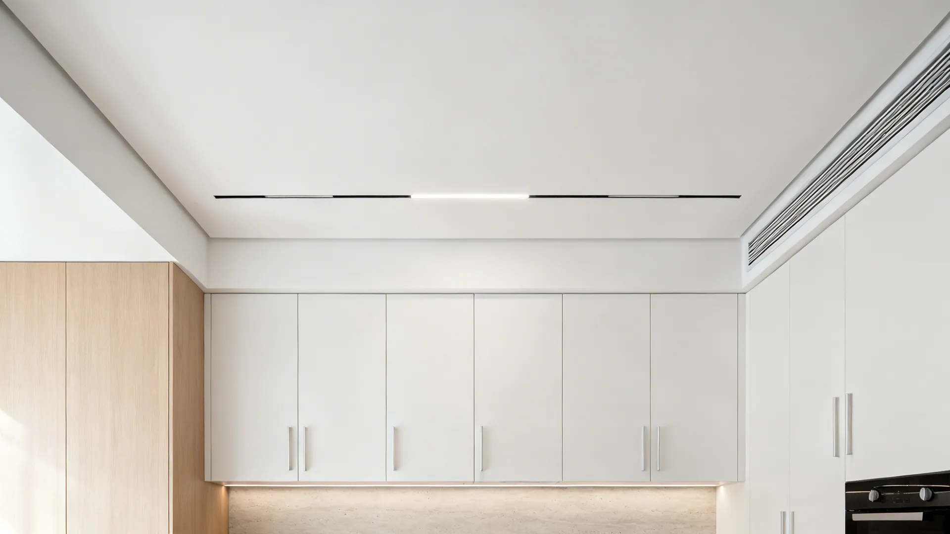 Minimal kitchen with monolithic gypsum ceiling and flush linear light slots.