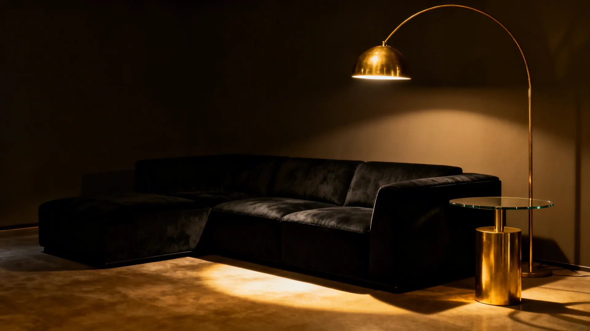 Black sofa under a brass arc lamp with warm metallic accents
