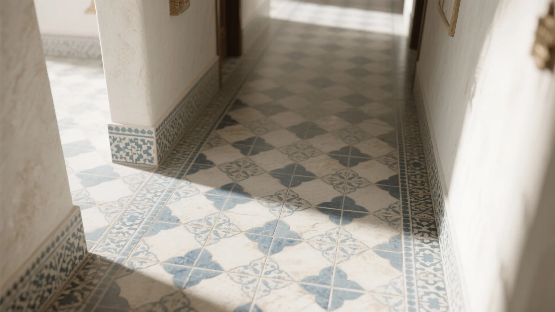 Narrow hallway featuring blue and white patterned floor tiles with white walls and natural sunlight