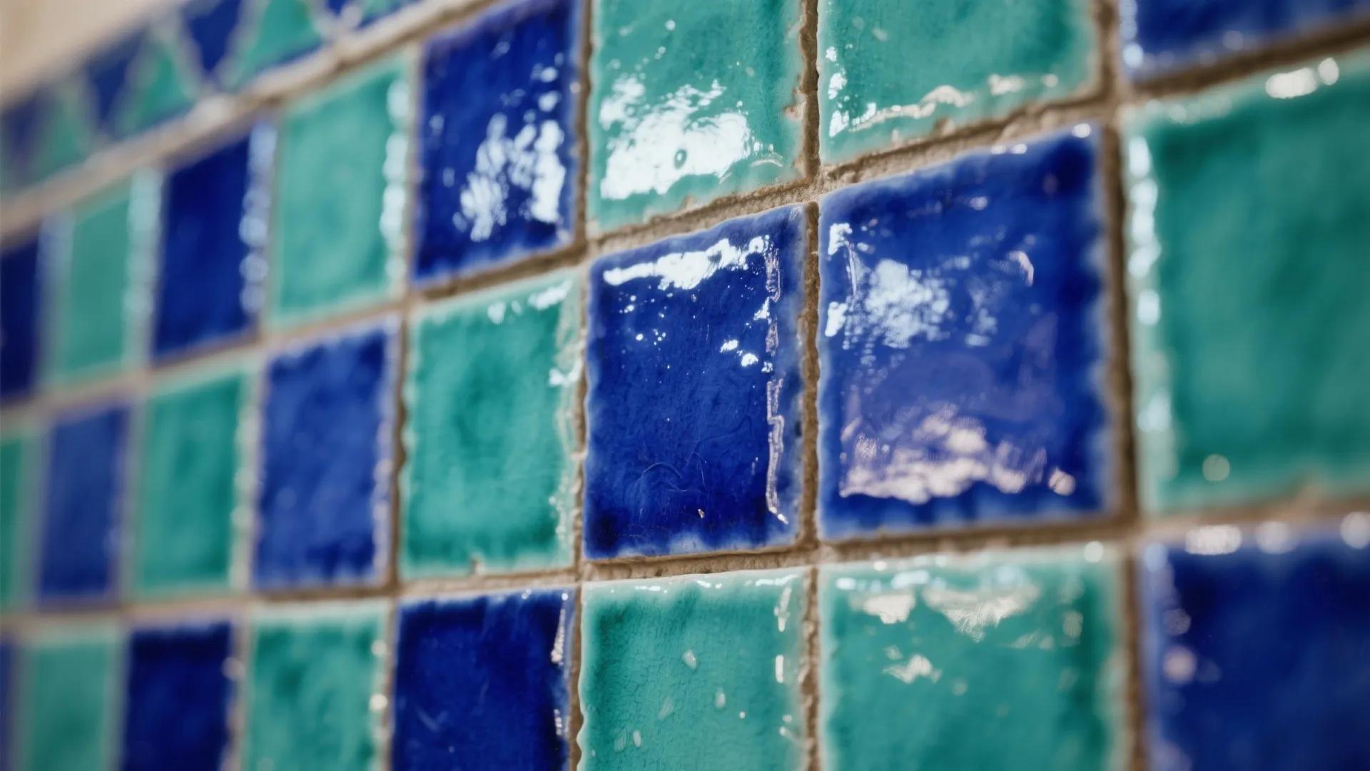 Close up of blue and turquoise square wall tiles with a glossy and textured surface