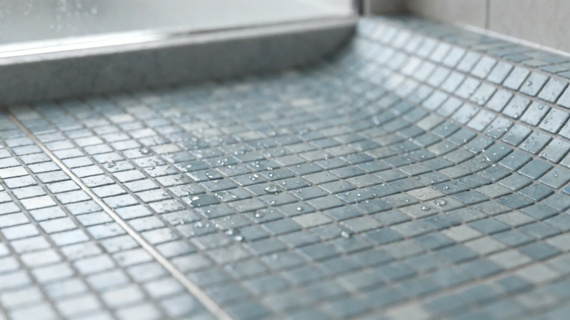 Close-up of small-format mosaic shower floor showing textured tiles and grout for slip resistance.