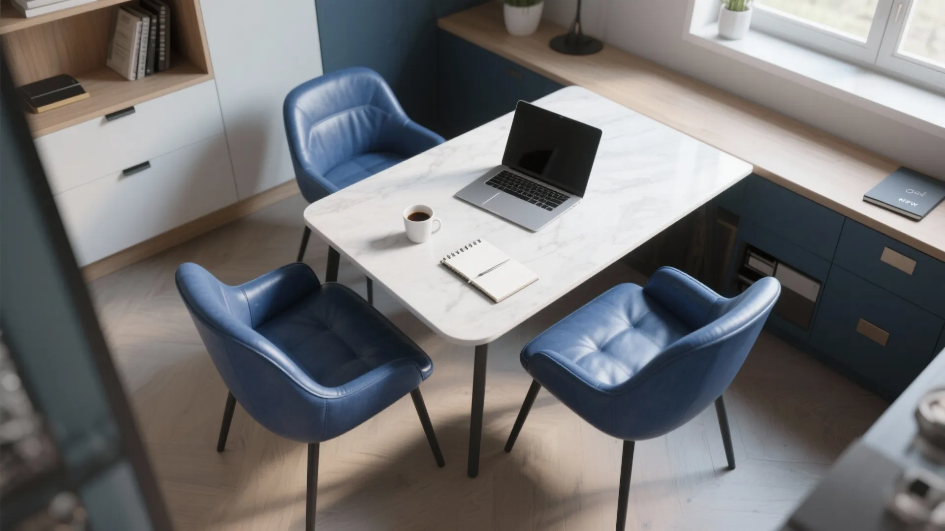 Top-down view of a compact dining/work area with blue leather chairs and laptop