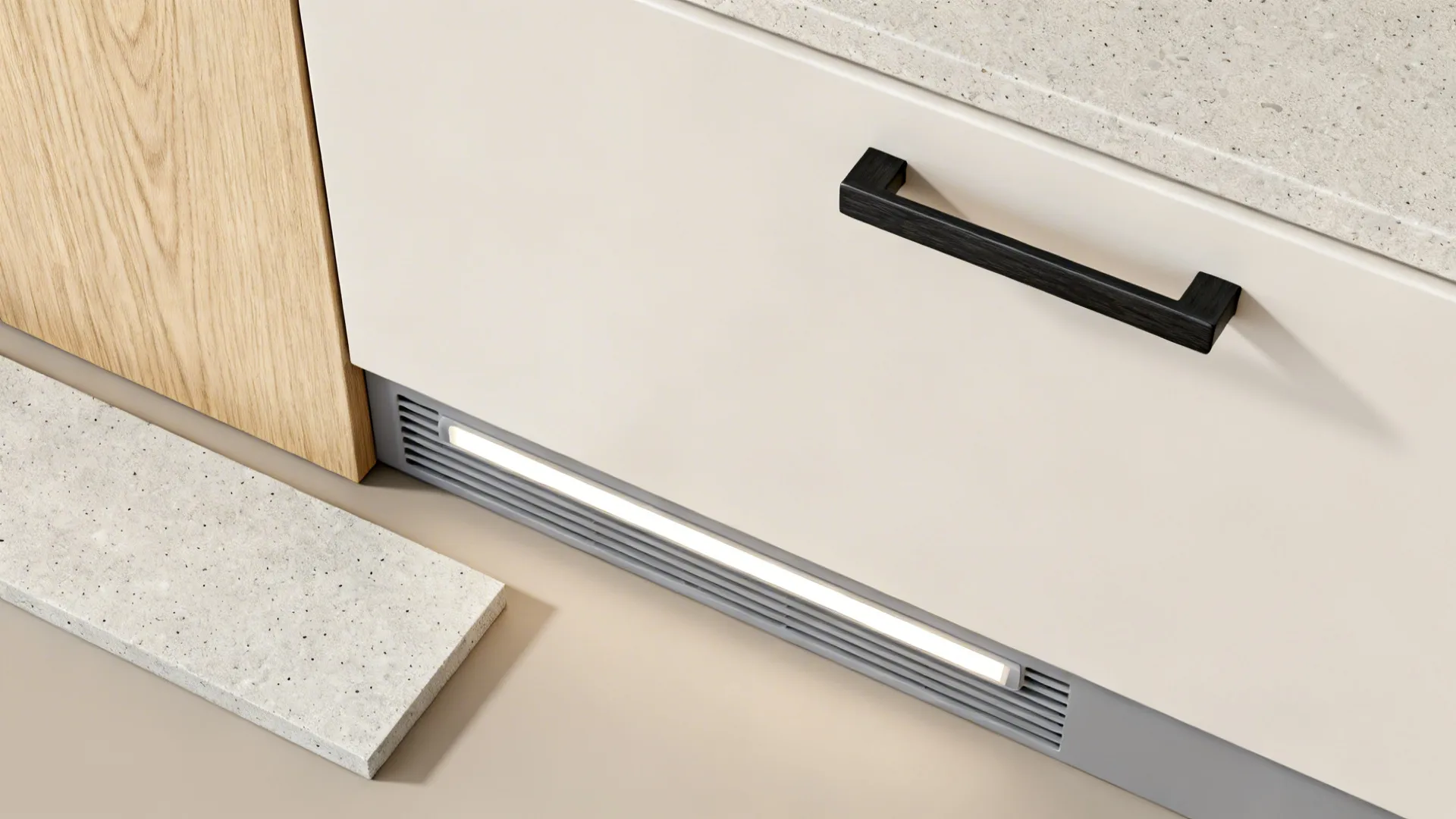 Close up of white kitchen cabinet drawer with black handle wood panel and grey stone tile